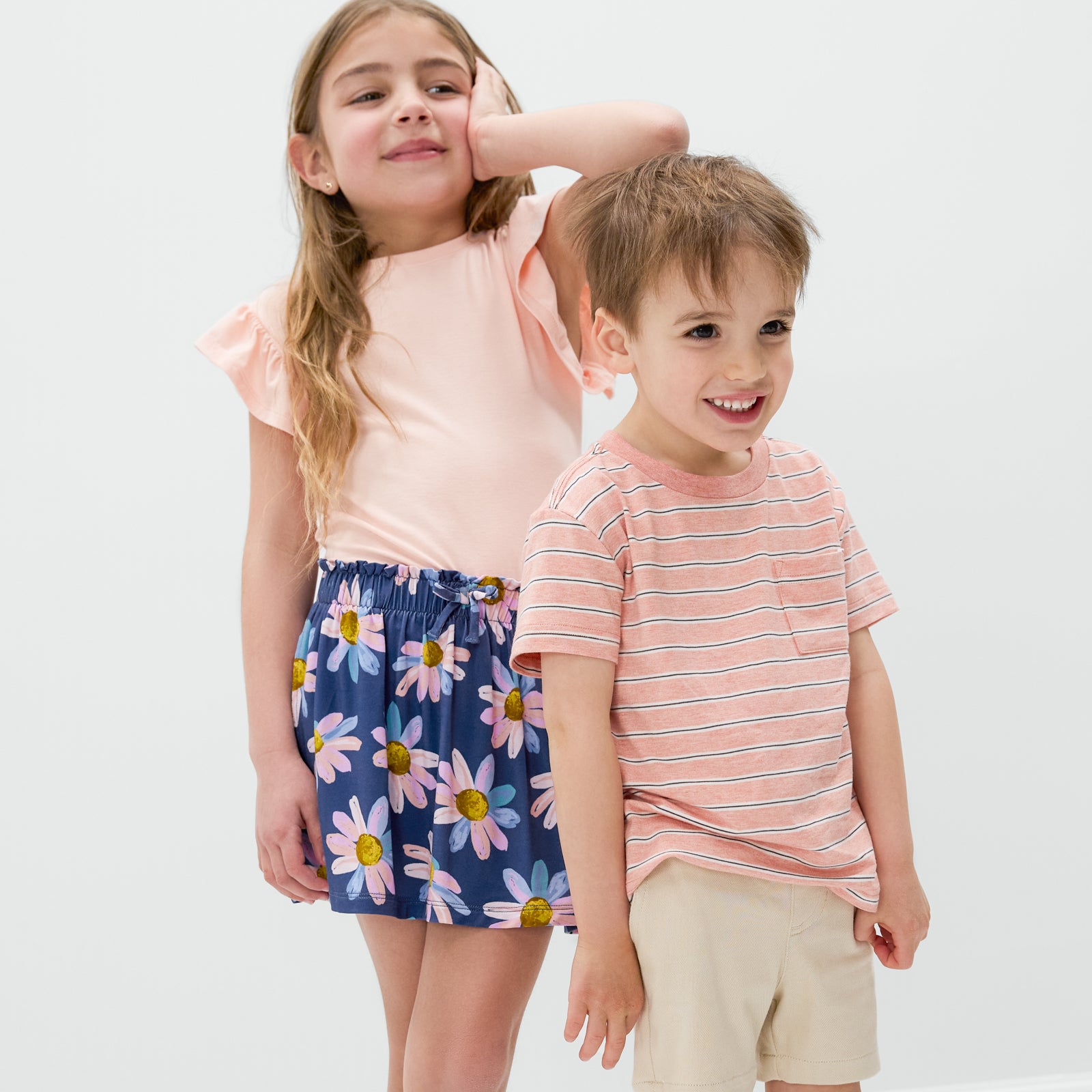 Two children wearing Coral Stripes and Daisy Blooms styles from the Spring Play Collection