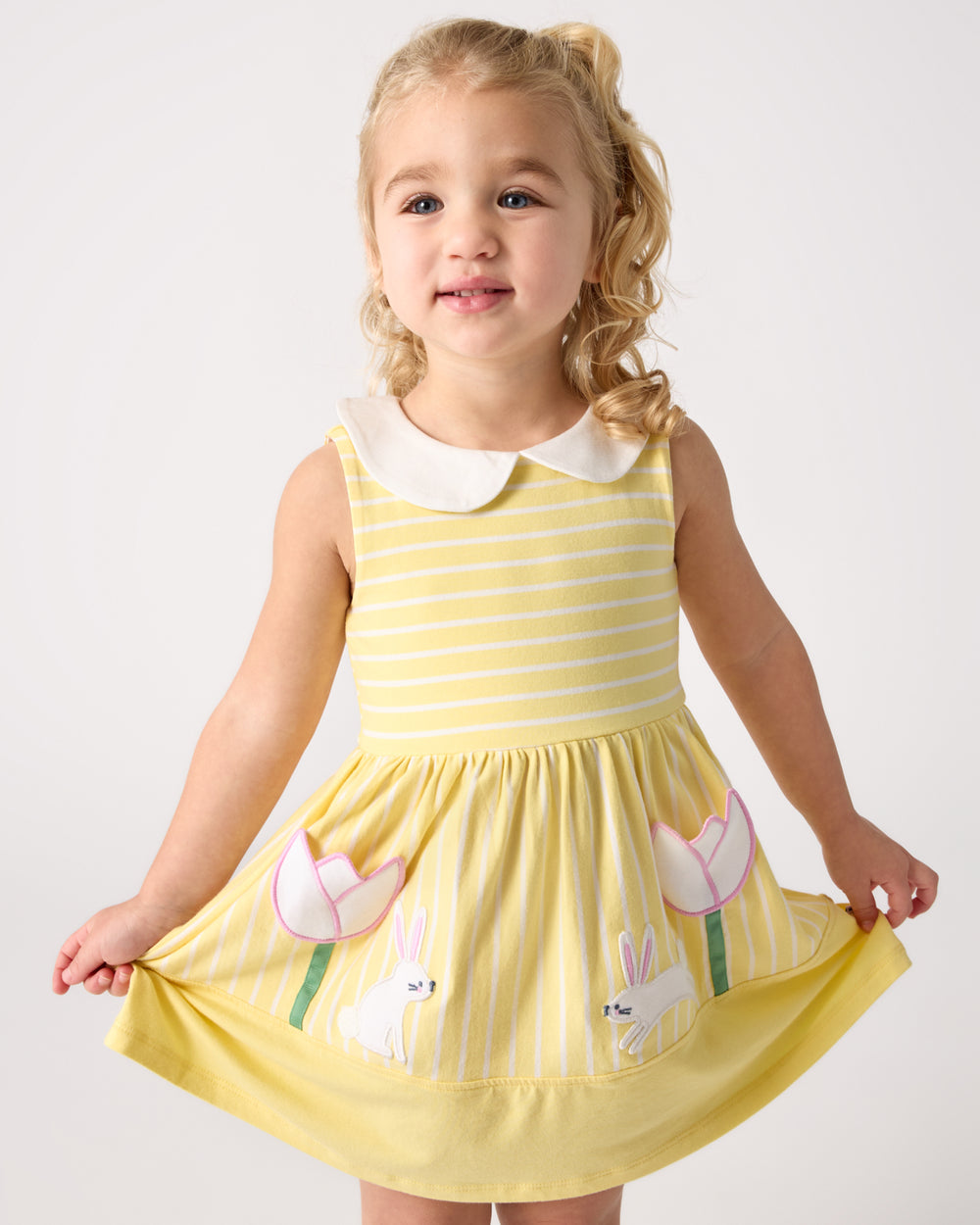 Girl wearing the Sunny Tulip Collar Skater Dress holding out the skirt