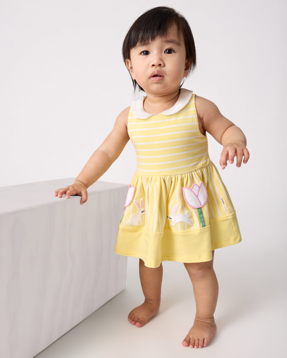 Standing baby wearing the Sunny Tulip Collar Skater Dress with Bloomer