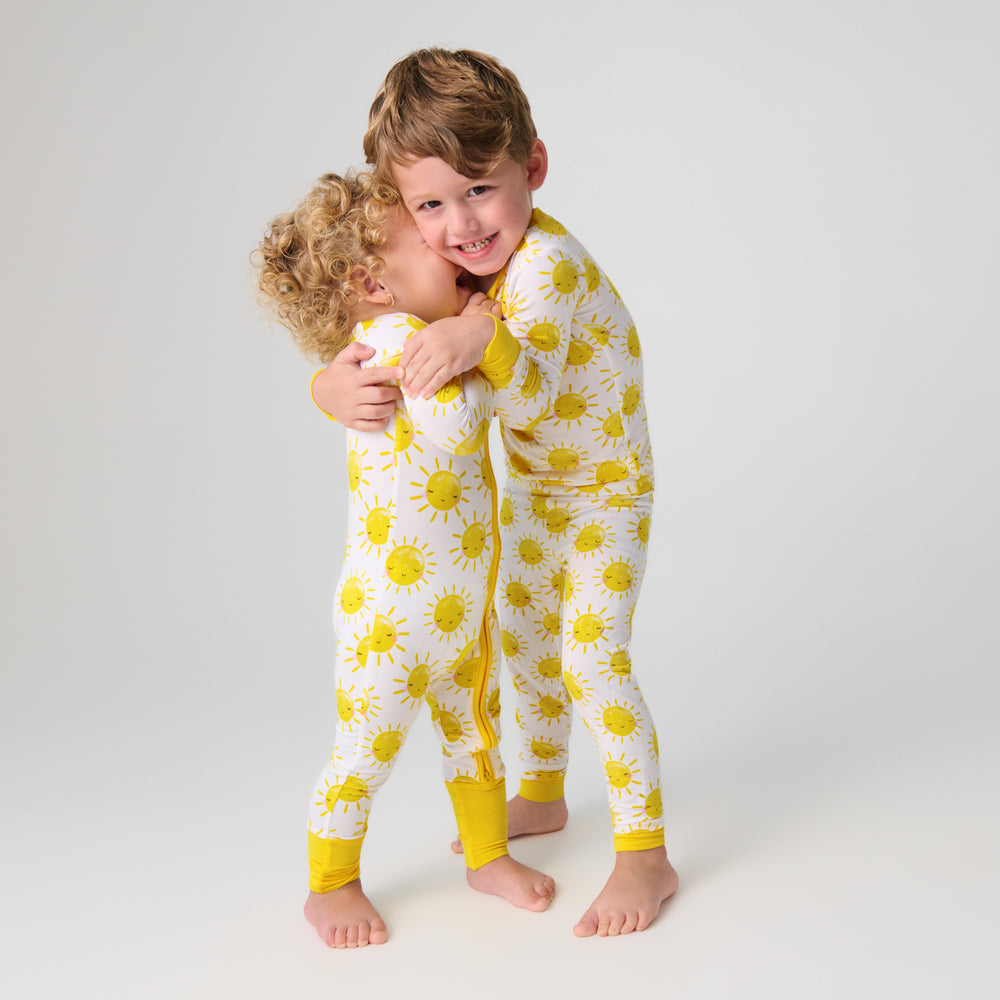 Two children wearing matching Sunshine Print Bamboo Pajamas