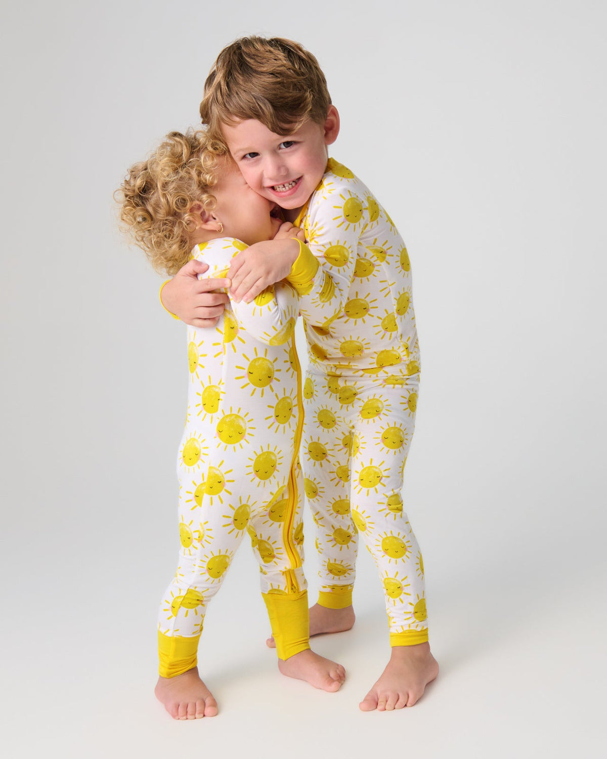 Two children wearing matching Sunshine Print Bamboo Pajamas