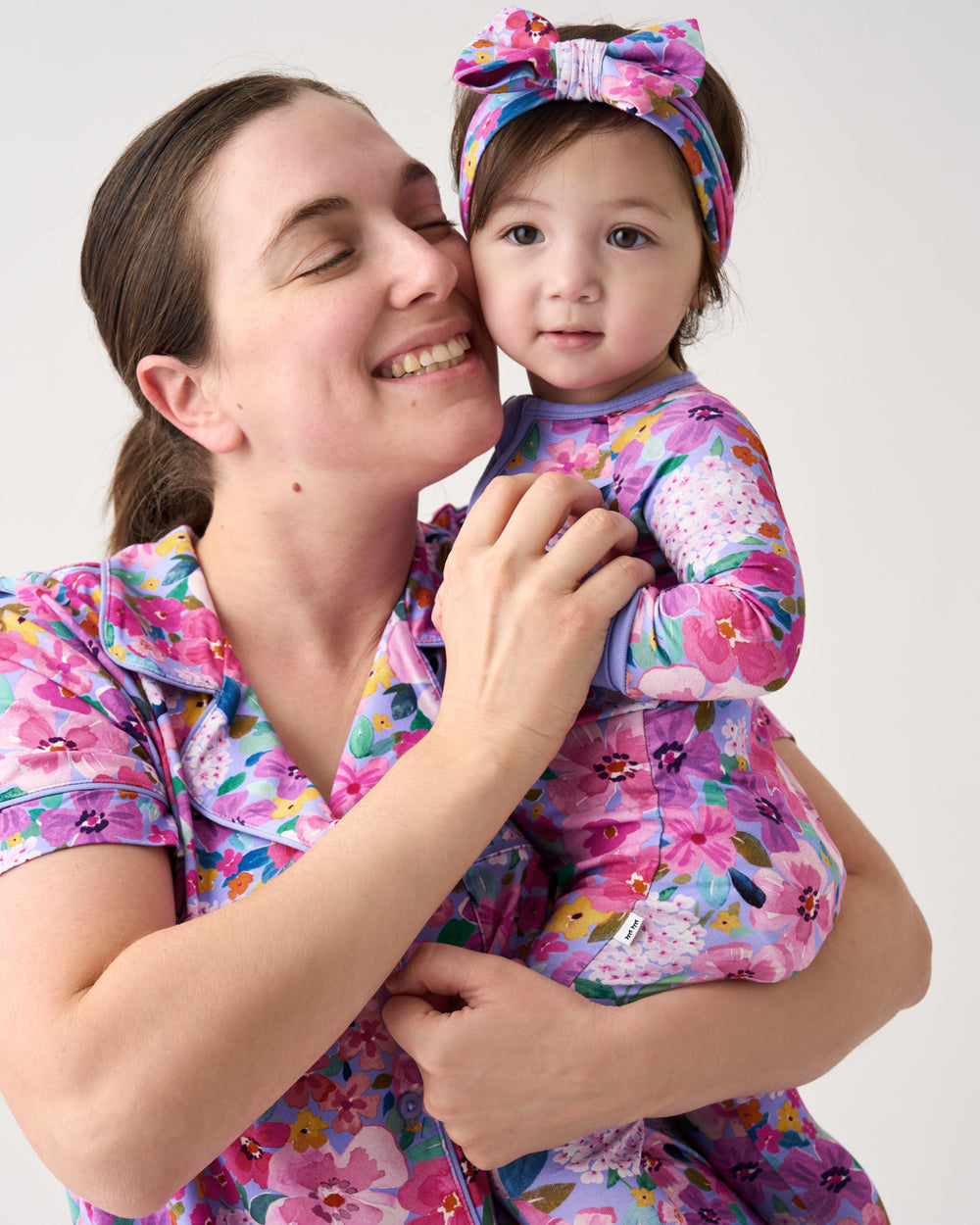 Mother holding toddler wearing the Sweet Sprigs Zippy with a Sweet Sprigs Luxe Bow Headband