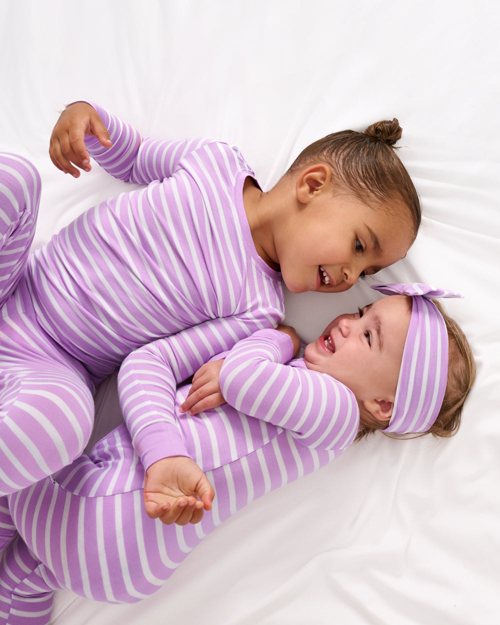 Two children wearing the Sweet Orchid Stripe Zippy and Two-Piece Set
