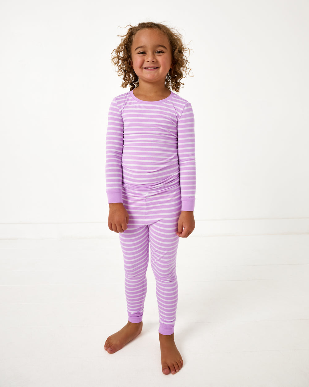 Standing girl wearing the Sweet Orchid Stripe Two-Piece Pajama Set