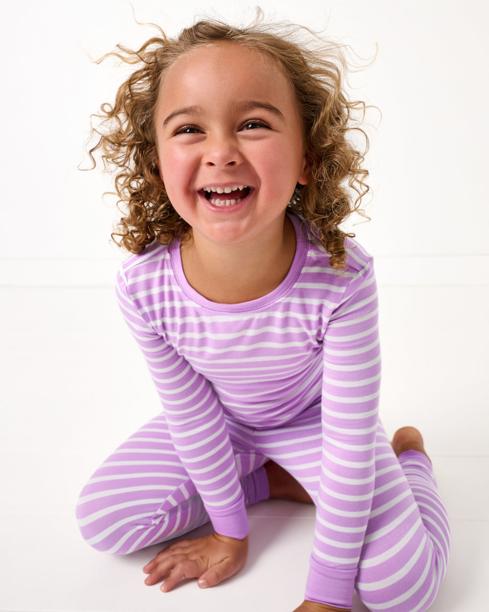 Sitting girl wearing the Sweet Orchid Stripe Two-Piece Pajama Set