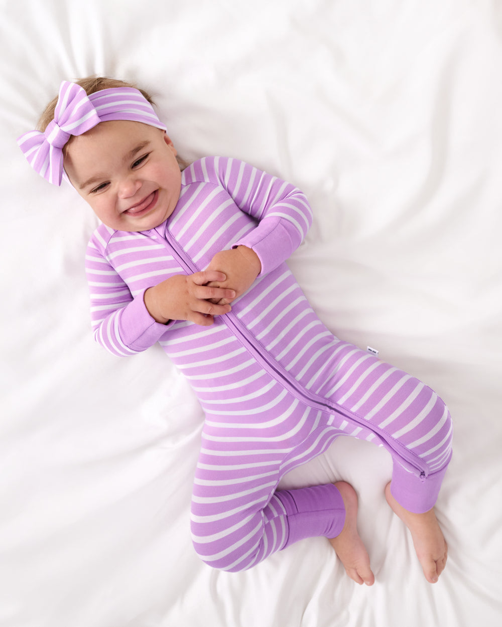 Aerial view of baby wearing the Sweet Orchid Stripe Zippy and Luxe Bow Headband