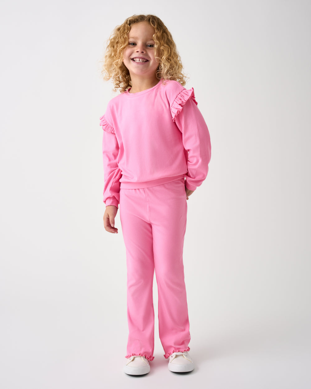 Standing girl wearing the Sweet Pink Ribbed Flutter Crewneck and Pants