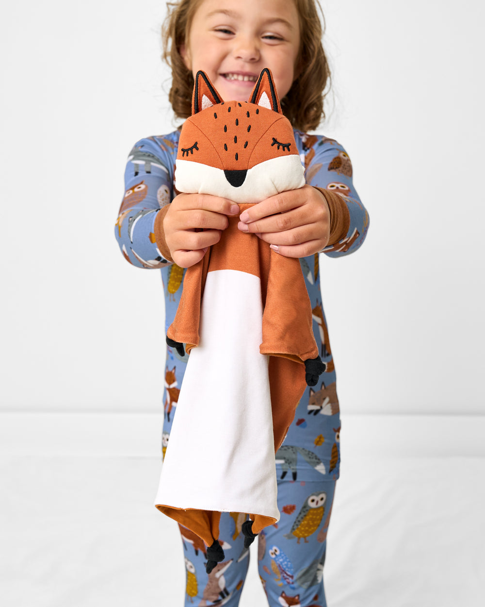 Child holding up the Felix the Fox Sleepyhead Lovey