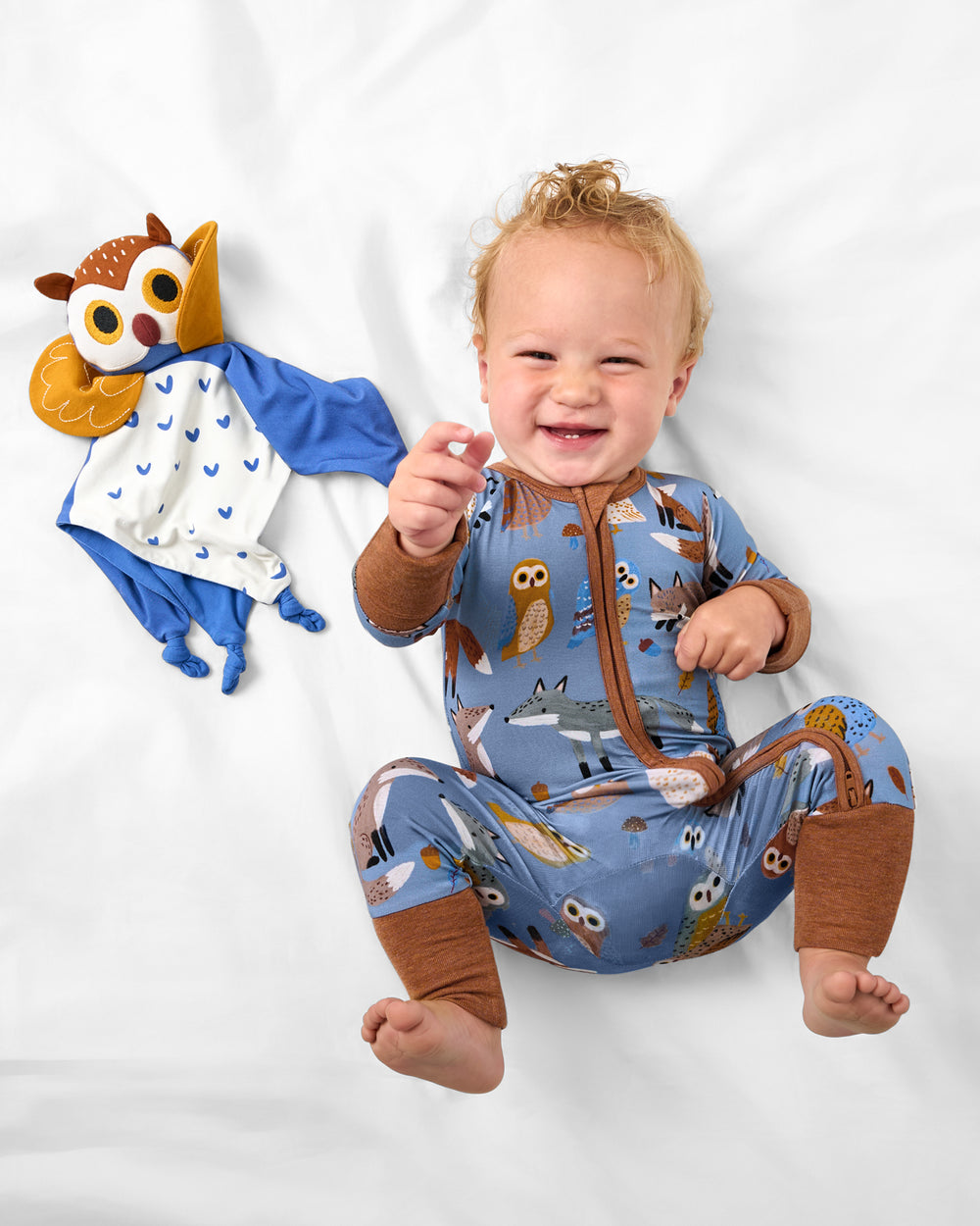 Child laying with the Echo the Owl Sleepyhead Lovey