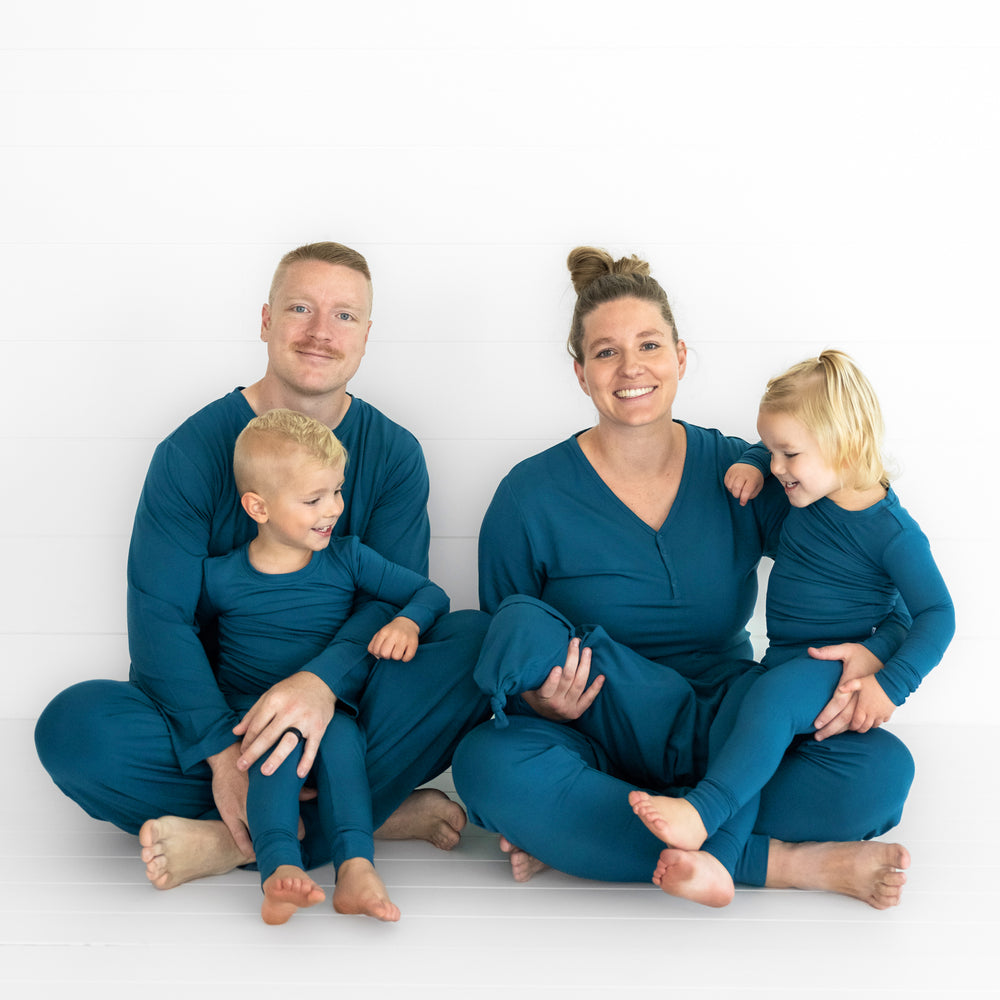 family of four wearing matching Cozy Twilight Teal pj sets in men's, women's, and children's two piece styles