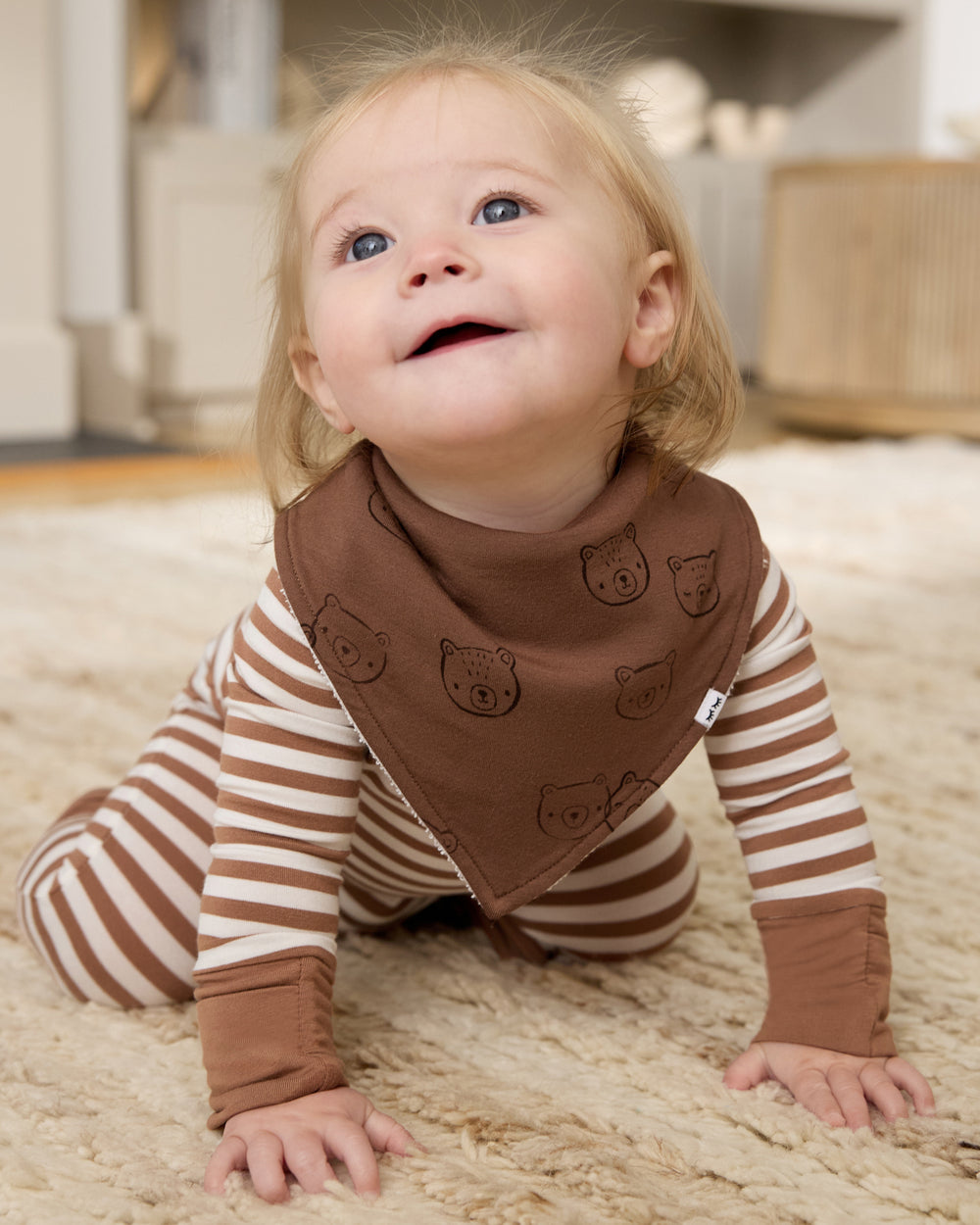Crawling newborn wearing the Teddy Tracks Bandana Bib