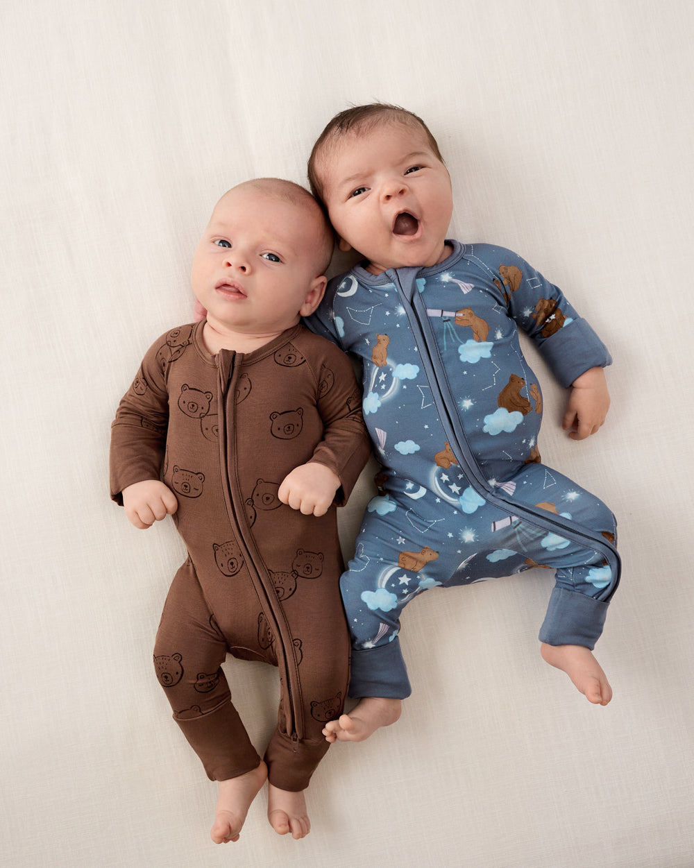 Two newborns wearing zippies from the Newborn Capsule