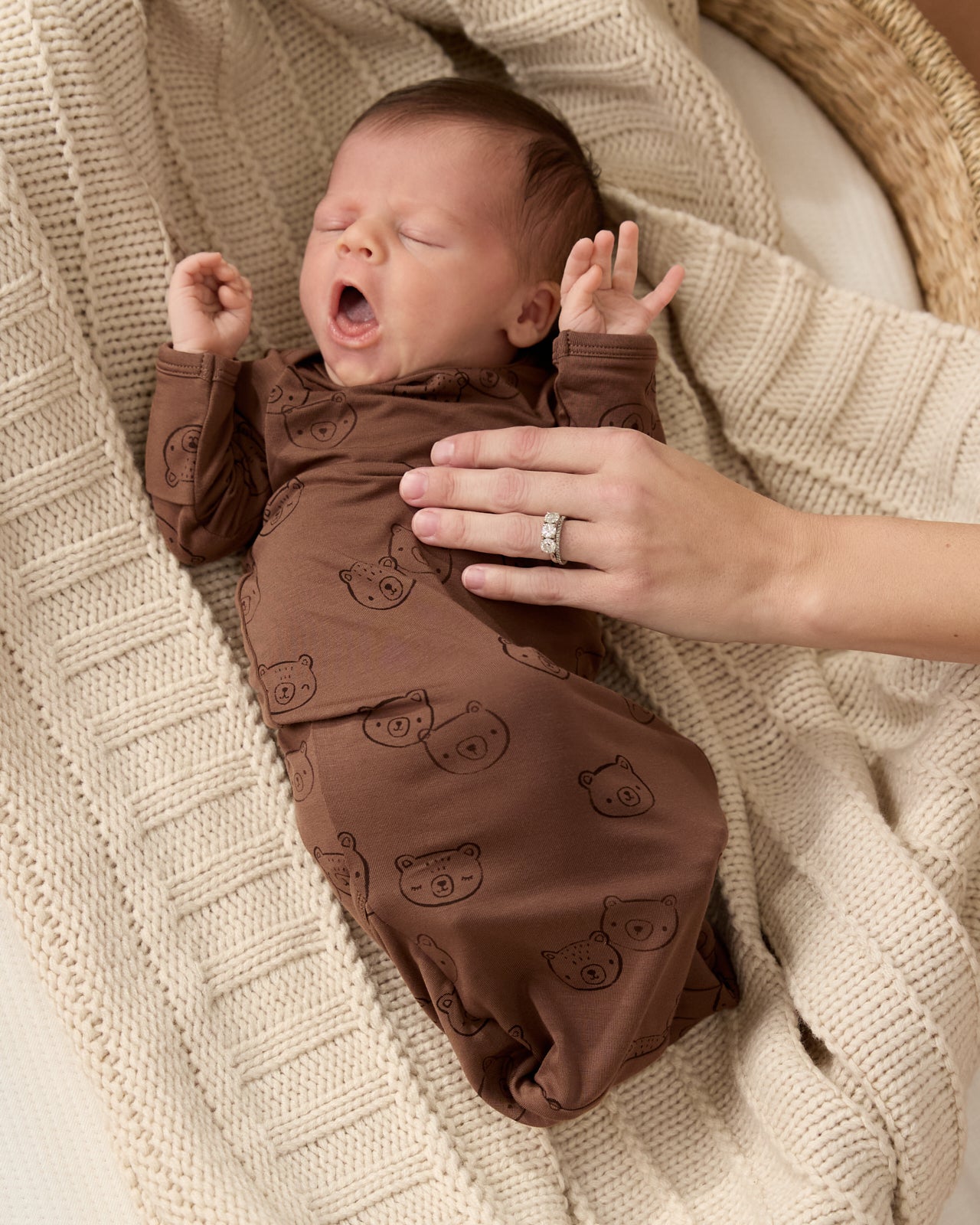 Newborn wearing the Teddy Tracks Infant Gown on a knit blanket
