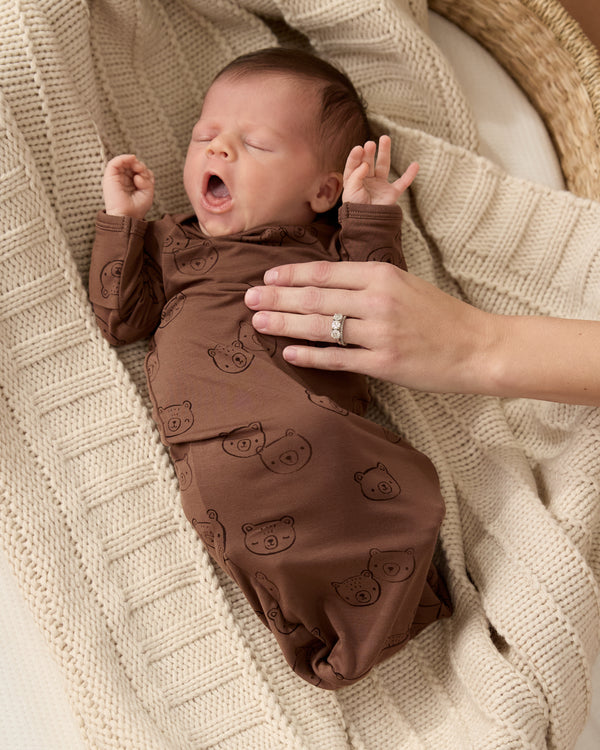 Newborn wearing the Teddy Tracks Infant Gown on a knit blanket