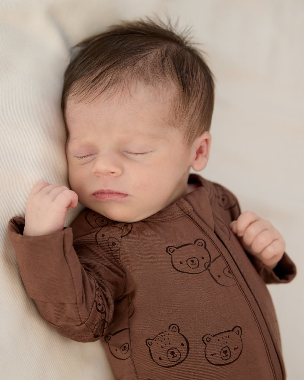 Close up of newborn wearing the Teddy Tracks Zippy