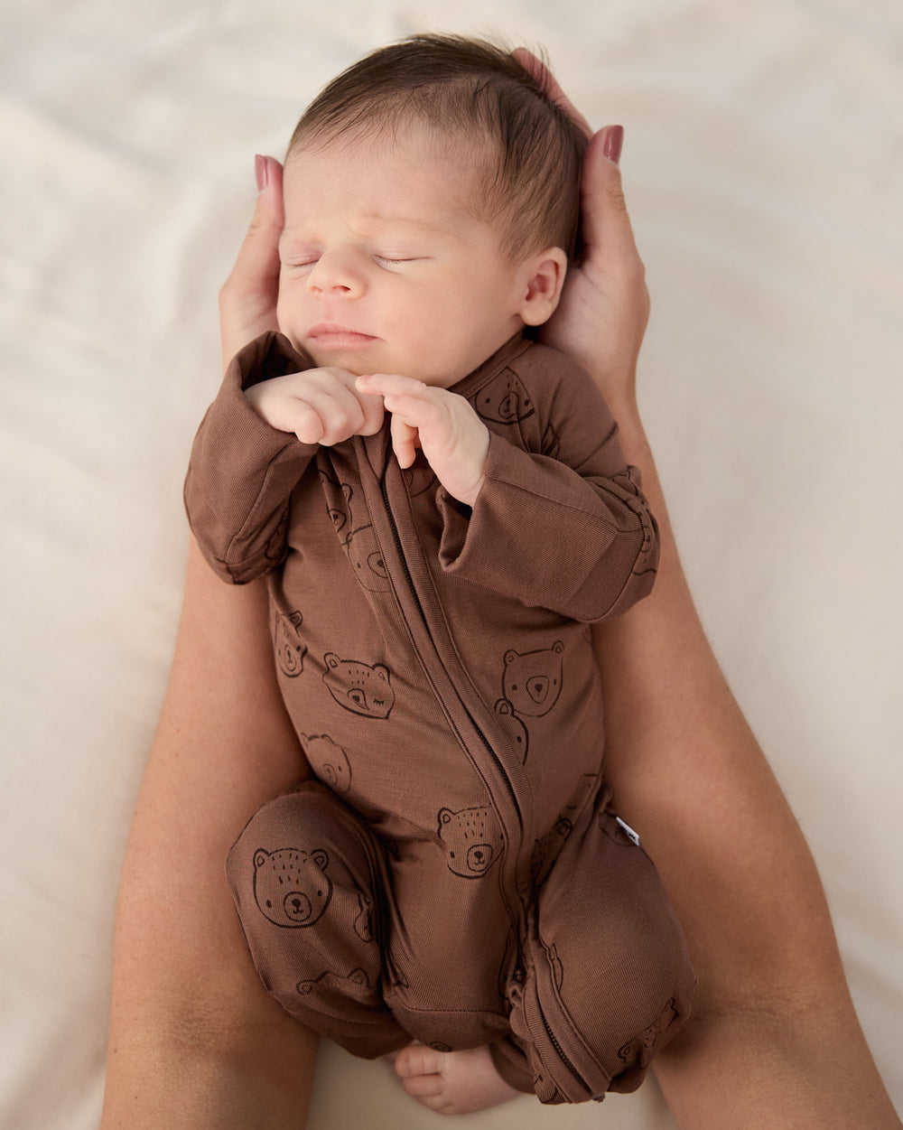 Adult holding baby wearing the Teddy Tracks Zippy