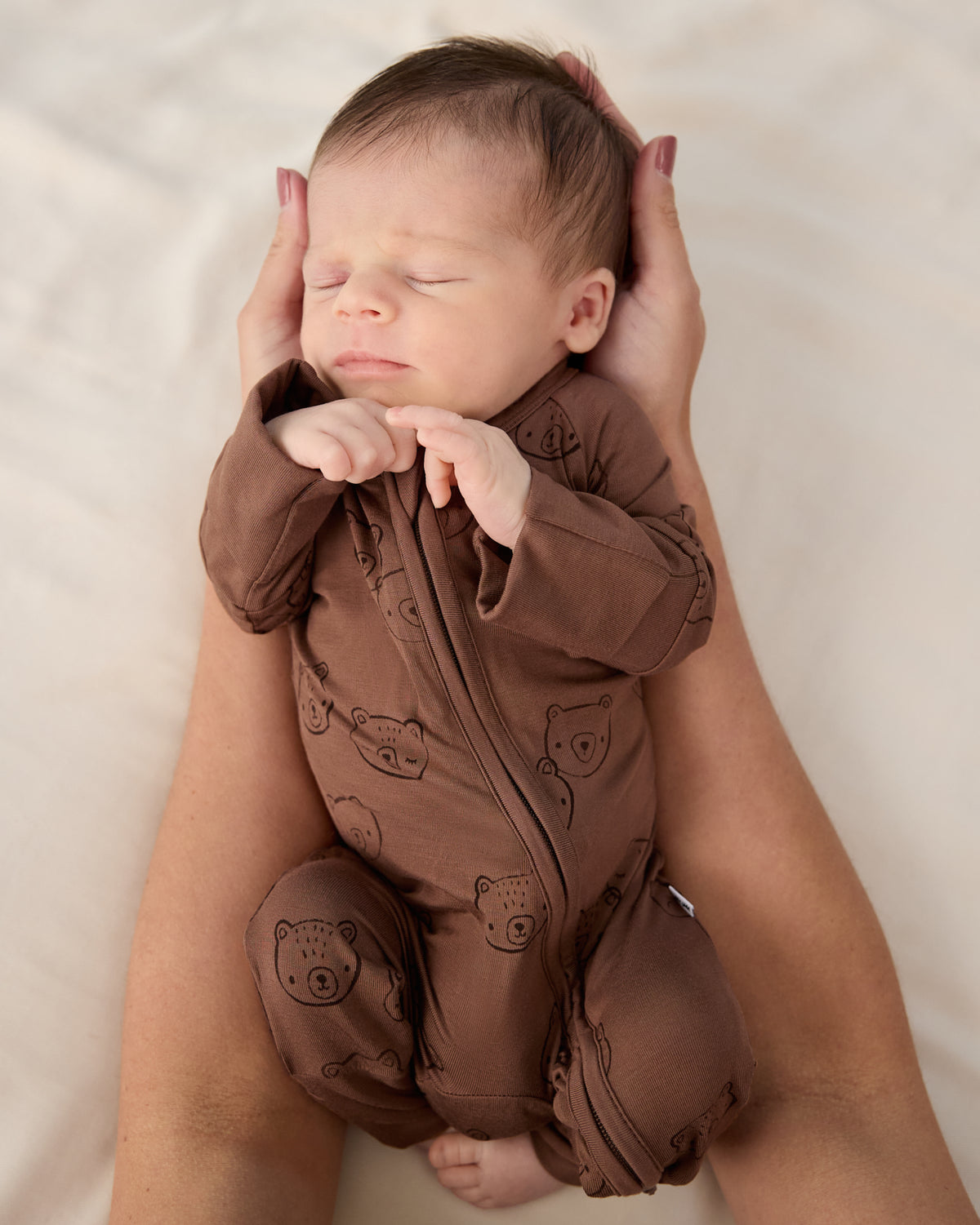 Adult holding baby wearing the Teddy Tracks Zippy