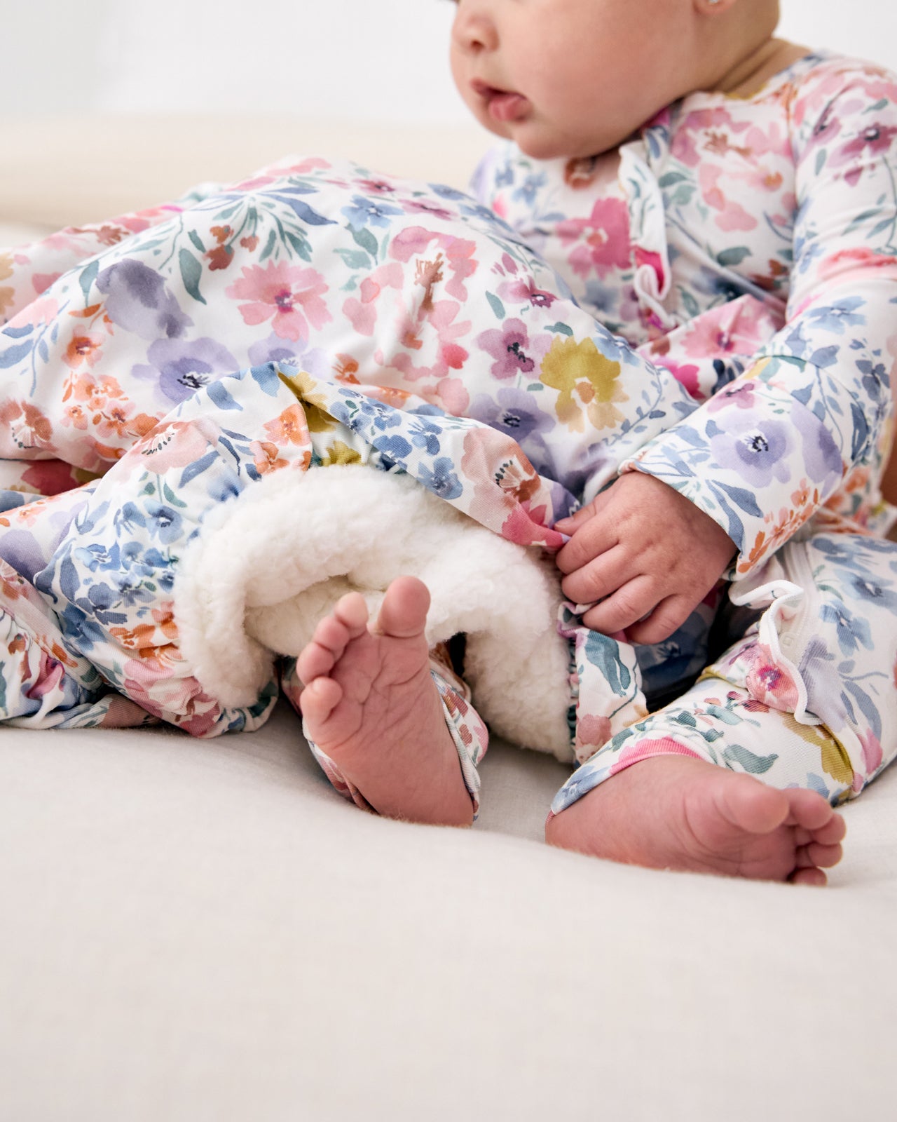 Baby snuggled in the Tiny Blooms Ruffle Mini Cloud Blanket