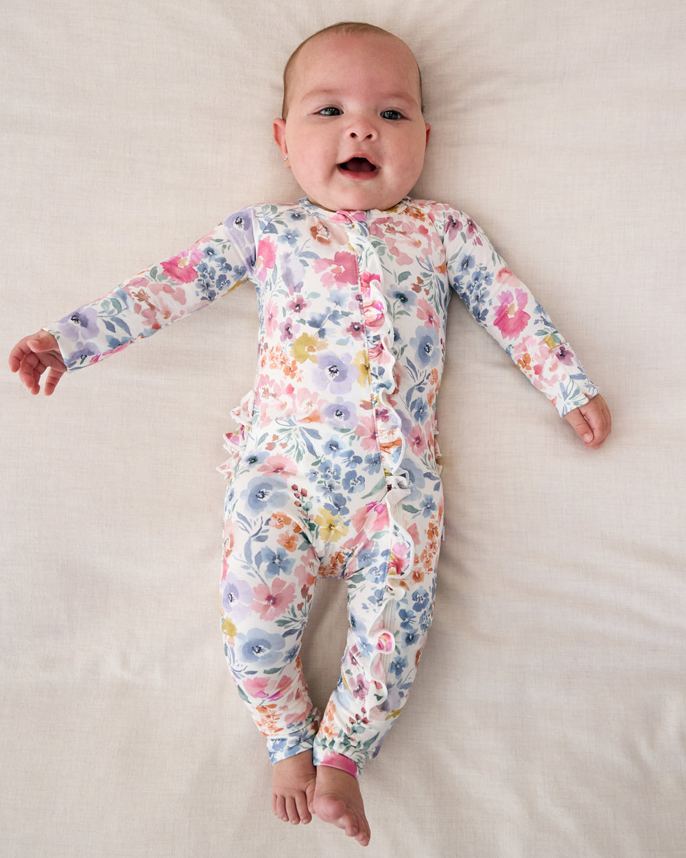 Aerial view of baby wearing the Tiny Blooms Ruffle Zippy