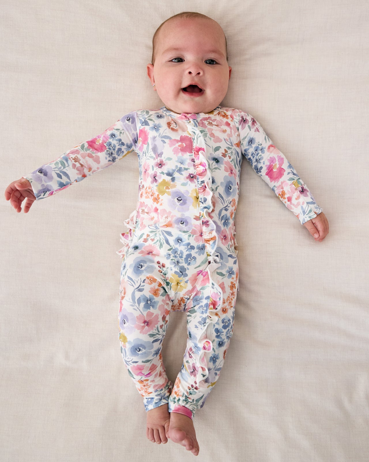 Aerial view of baby wearing the Tiny Blooms Ruffle Zippy