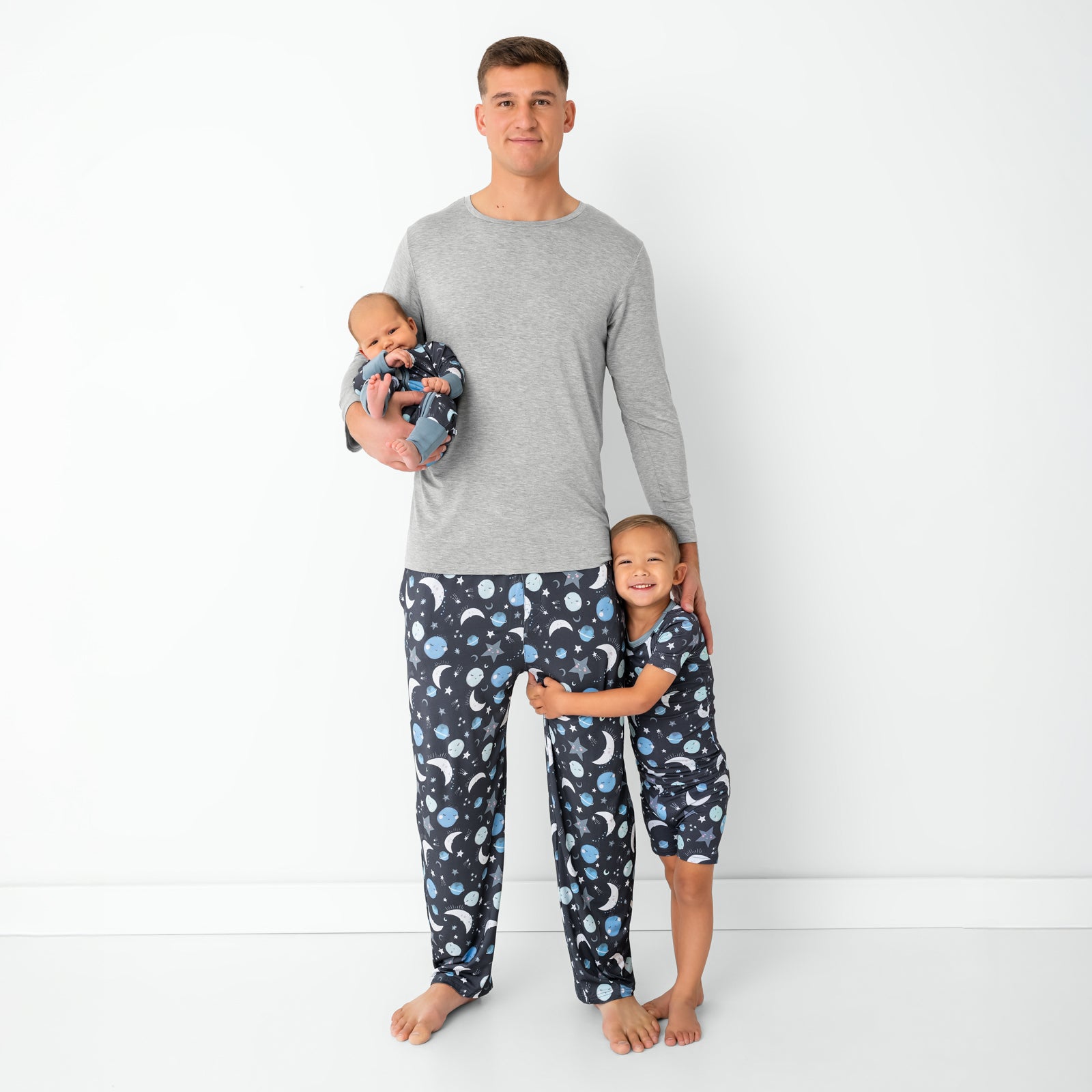 Father and two children wearing matching Blue To the Moon & Back pajamas