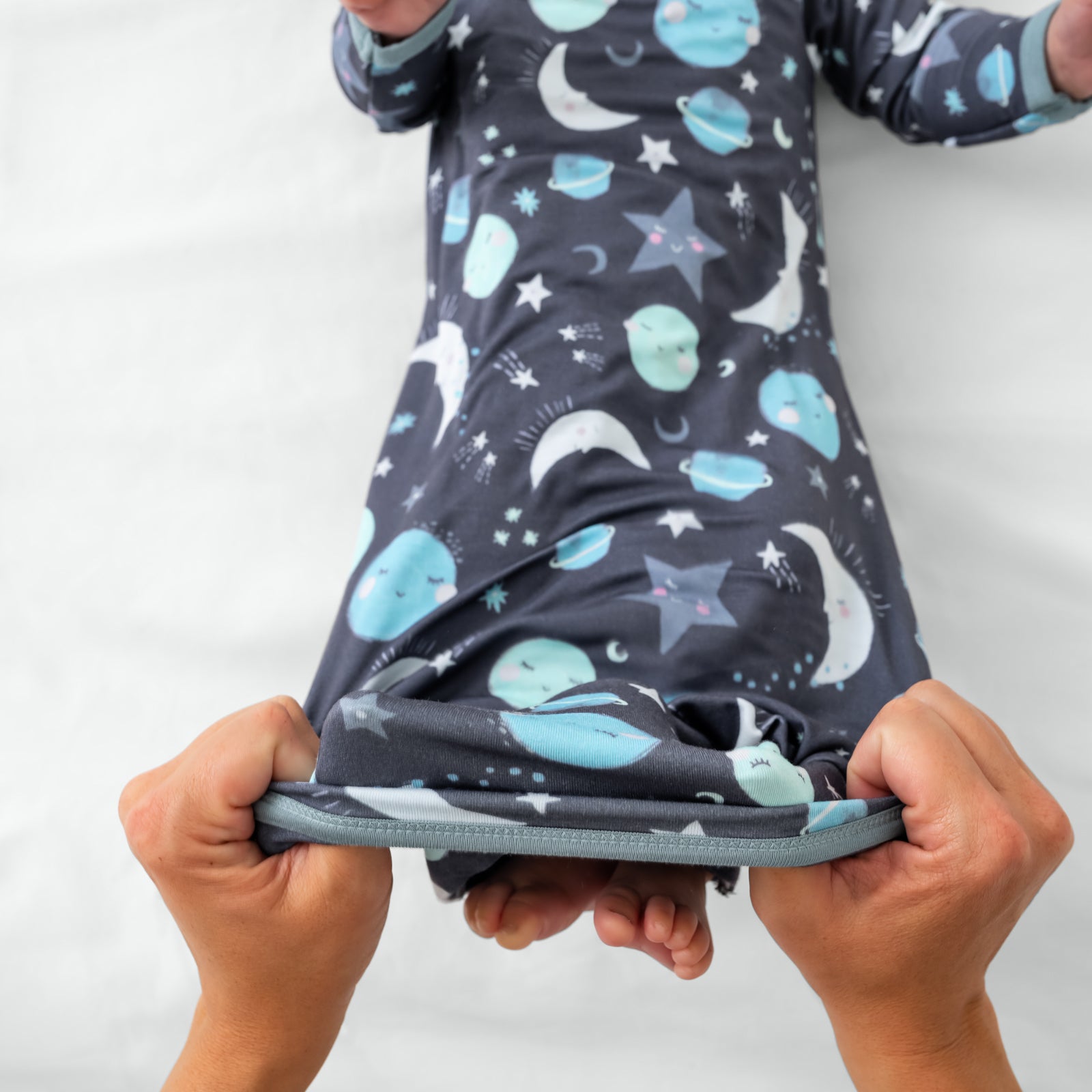 Aerial view of adult demonstrating the envelope sweep on the Blue To the Moon & Back Infant Gown