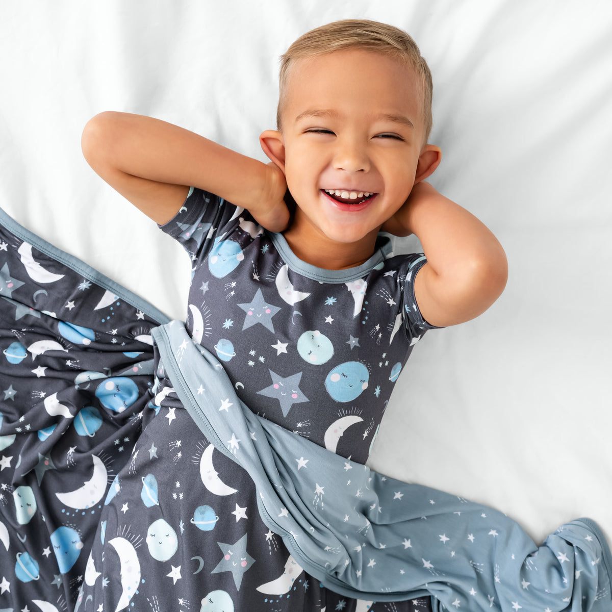 Aerial view of child wrapped in the Blue To the Moon & Back Large Cloud Blanket®