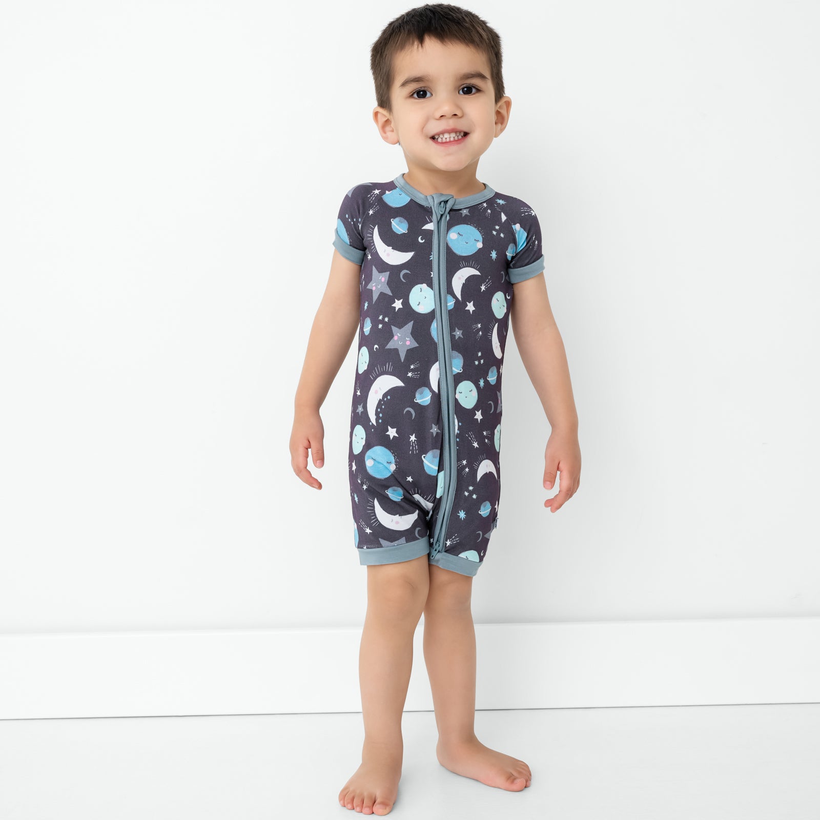 Standing child wearing the Blue To the Moon & Back Shorty Zippy