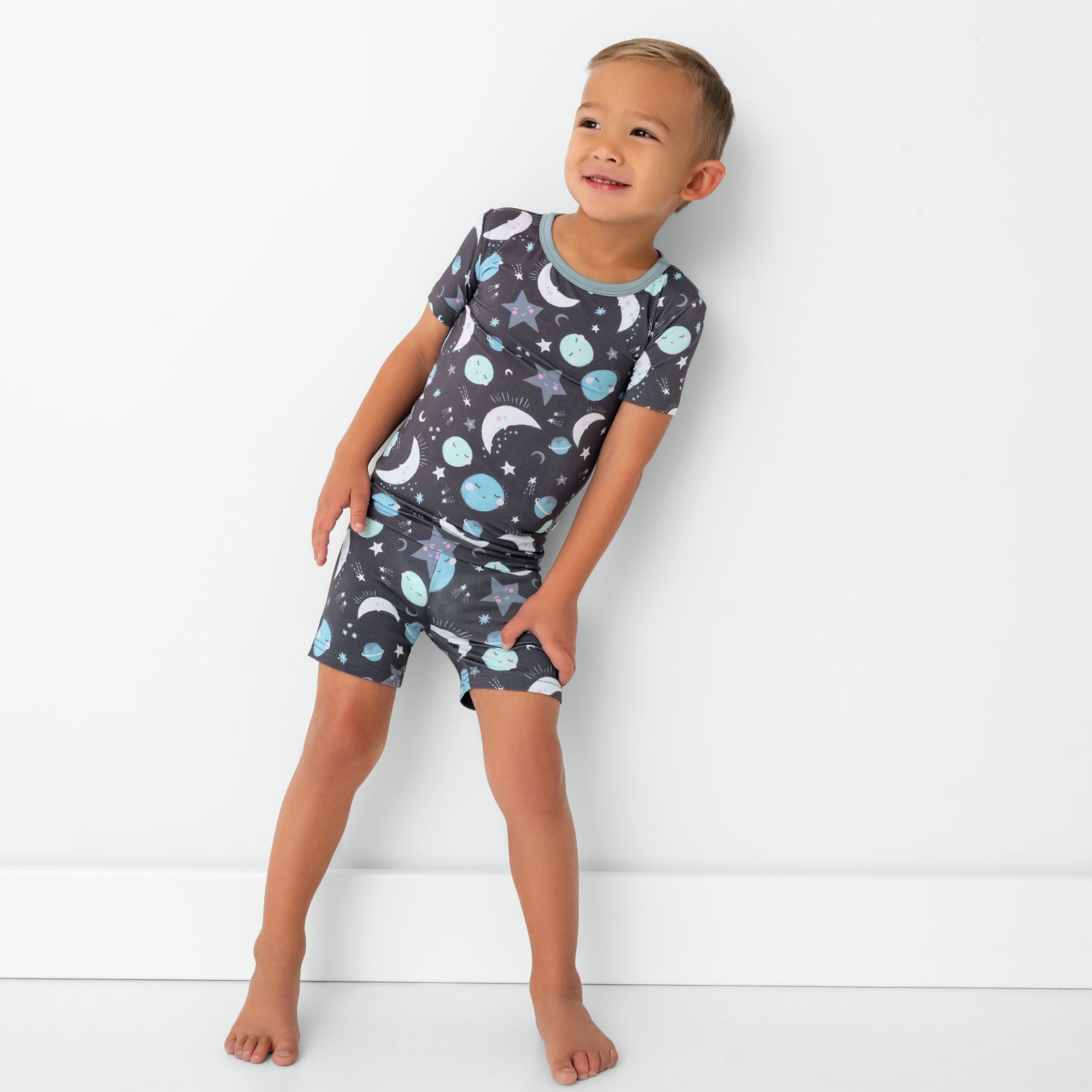 Standing child wearing the Blue To the Moon & Back Two-Piece Short Sleeve & Shorts Pajama Set