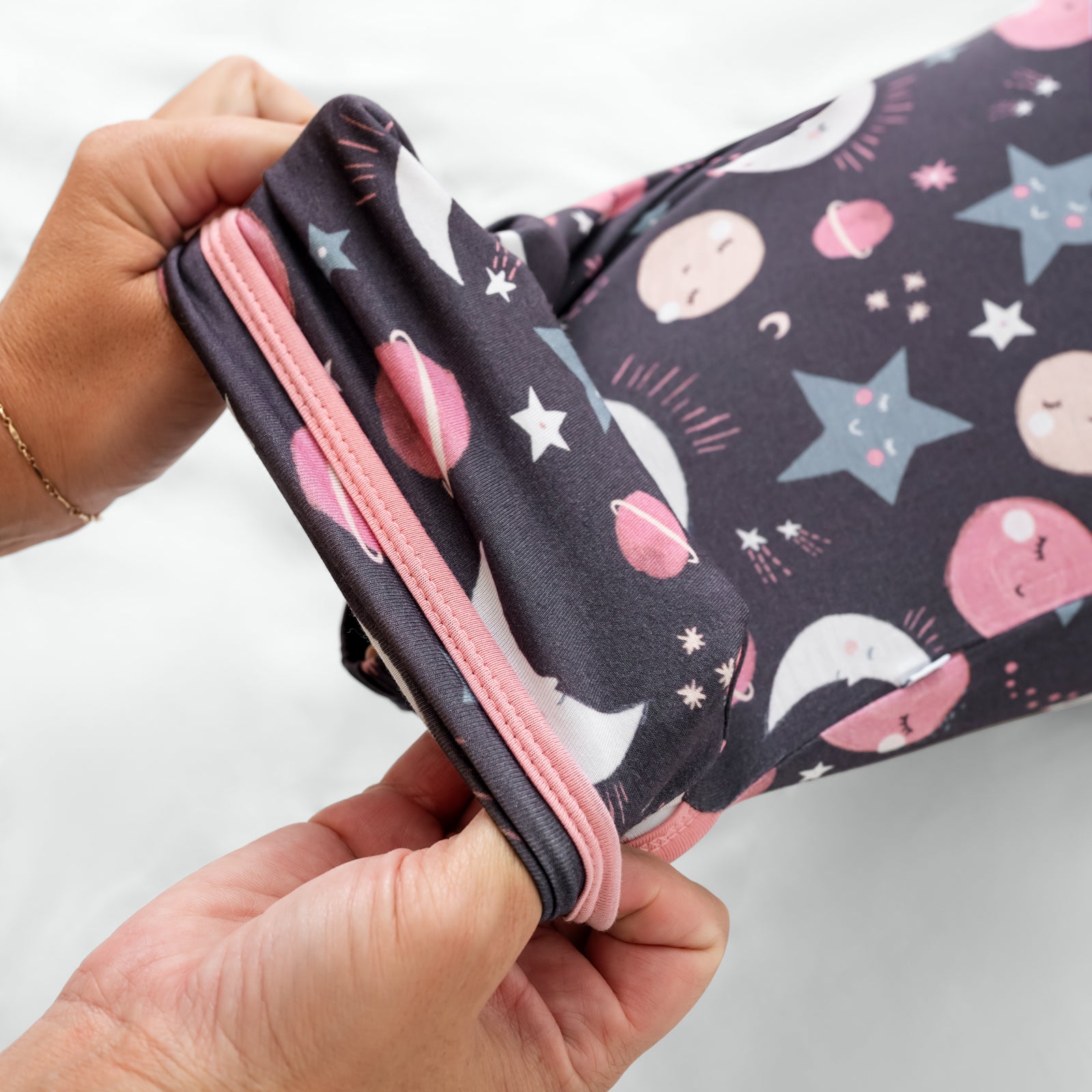 Adult demonstrating the envelope sweep on the Pink To the Moon & Back Infant Gown