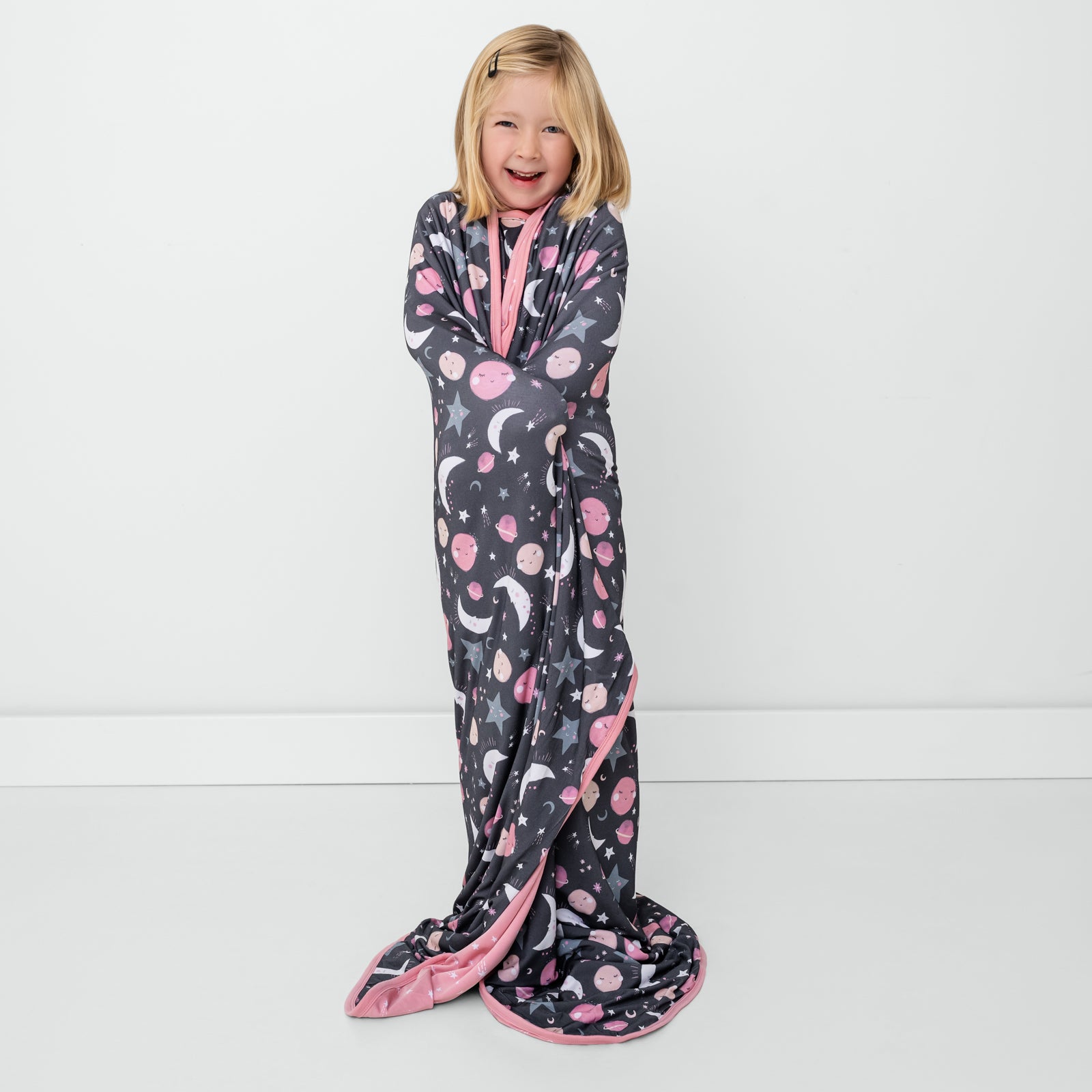 Standing girl wrapped in the Pink To the Moon & Back Large Cloud Blanket®