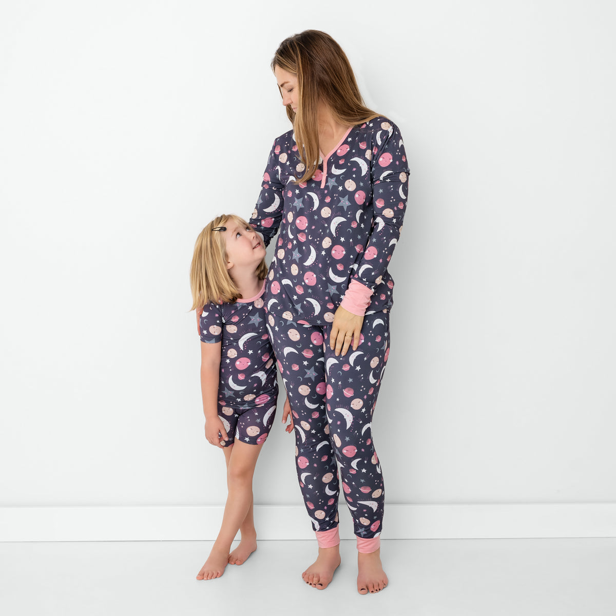 Standing mother and daughter wearing matching Pink To the Moon & Back pajamas