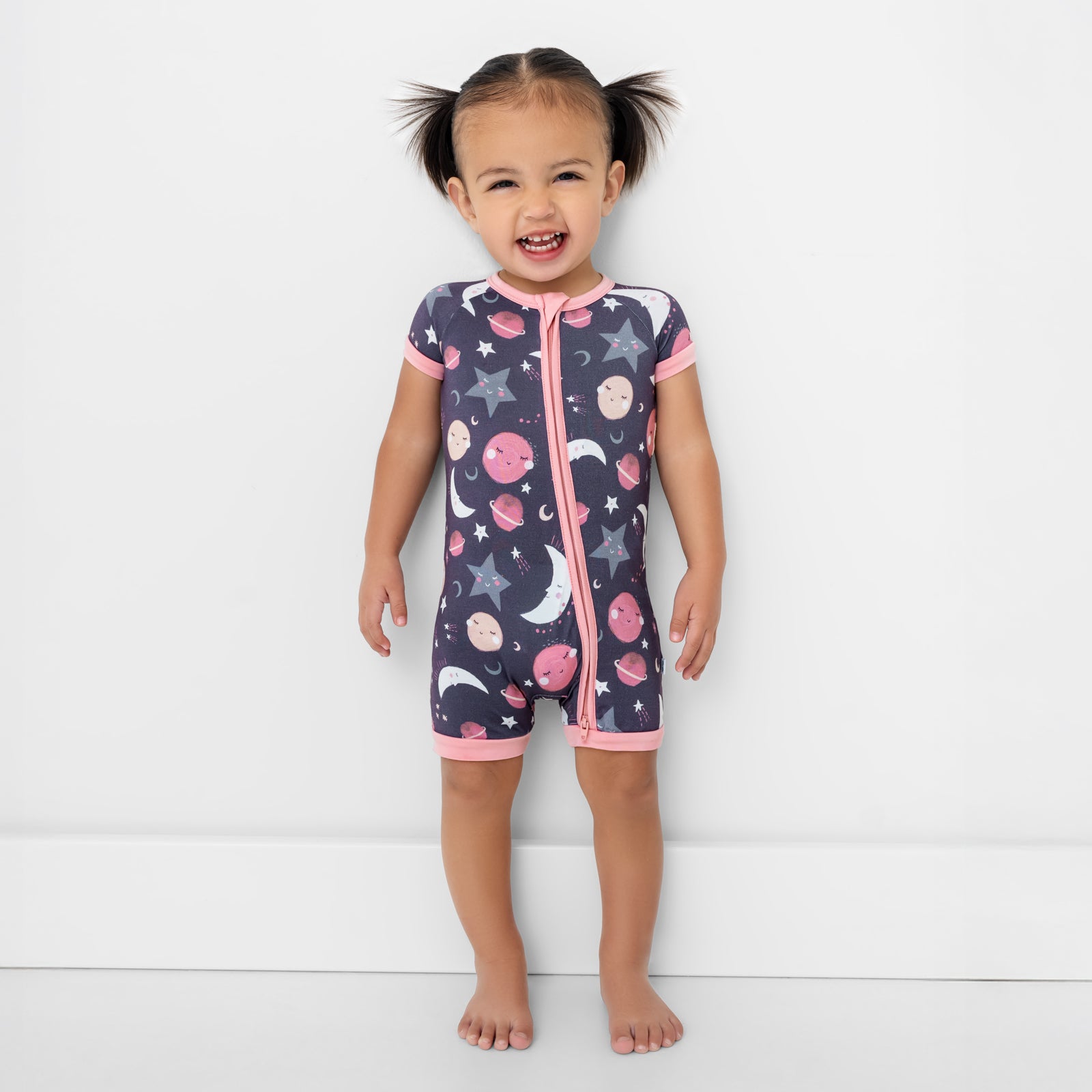 Standing child wearing the Pink To the Moon & Back Shorty Zippy