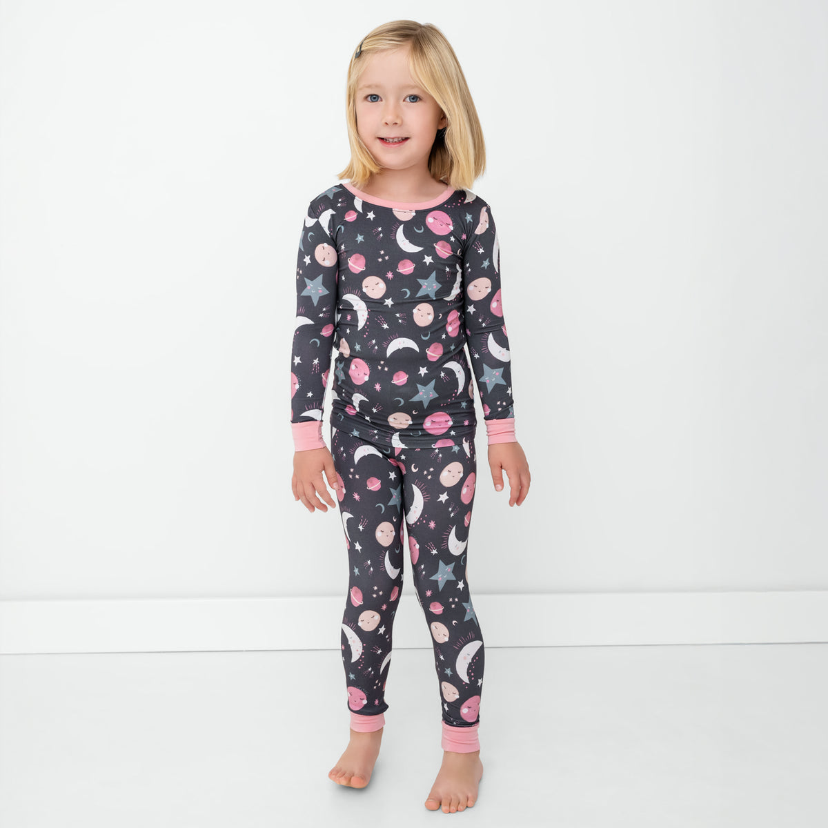 Standing child wearing the Pink To the Moon & Back Two-Piece Pajama Set