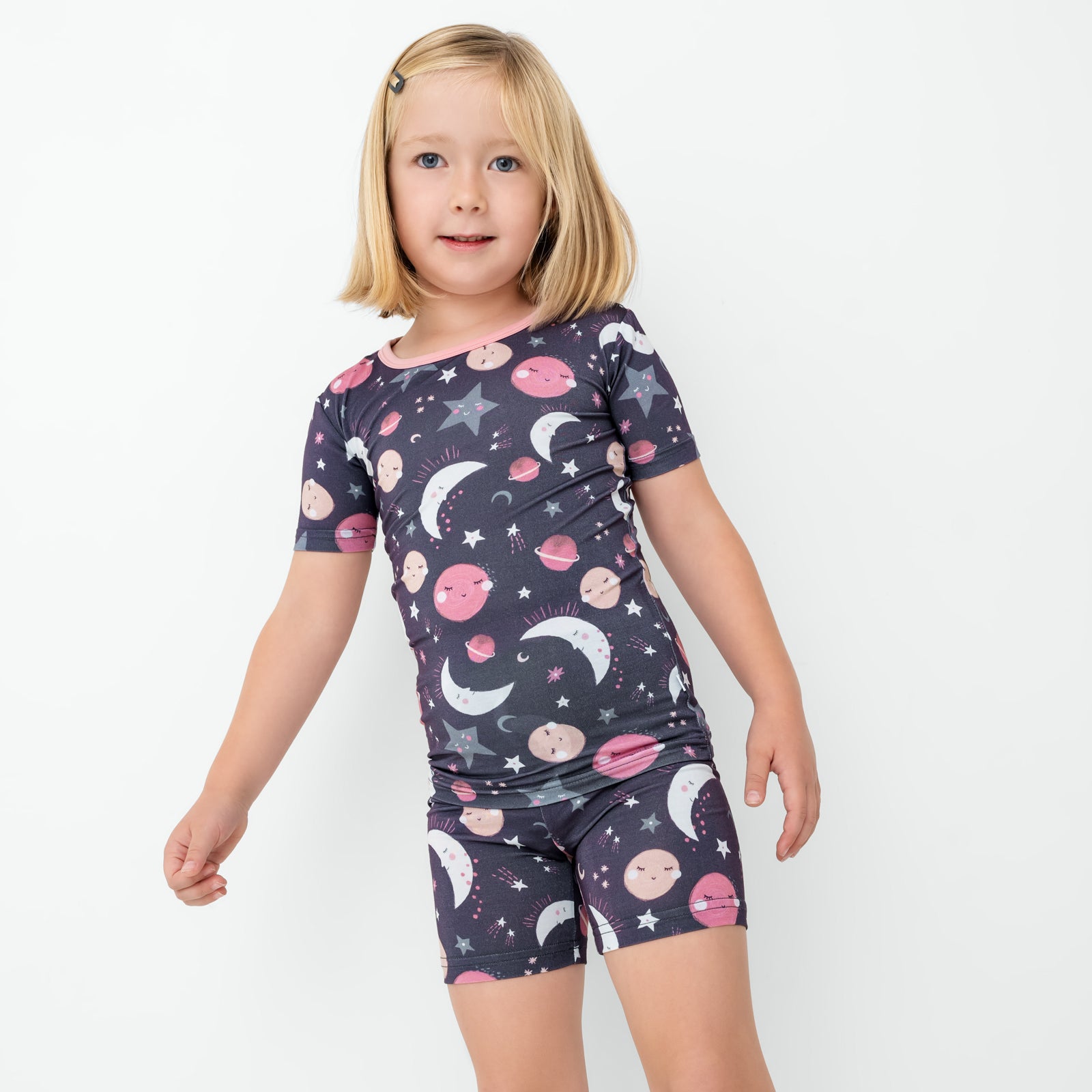 Standing child wearing the Pink To the Moon & Back Two-Piece Short Sleeve & Shorts Pajama Set