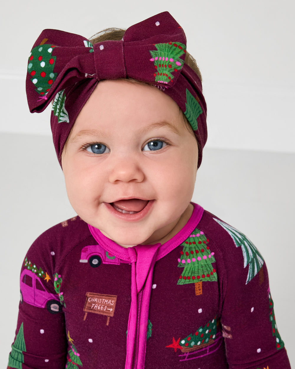 Close up of baby wearing the Cranberry Tree Traffic Luxe Bow Headband
