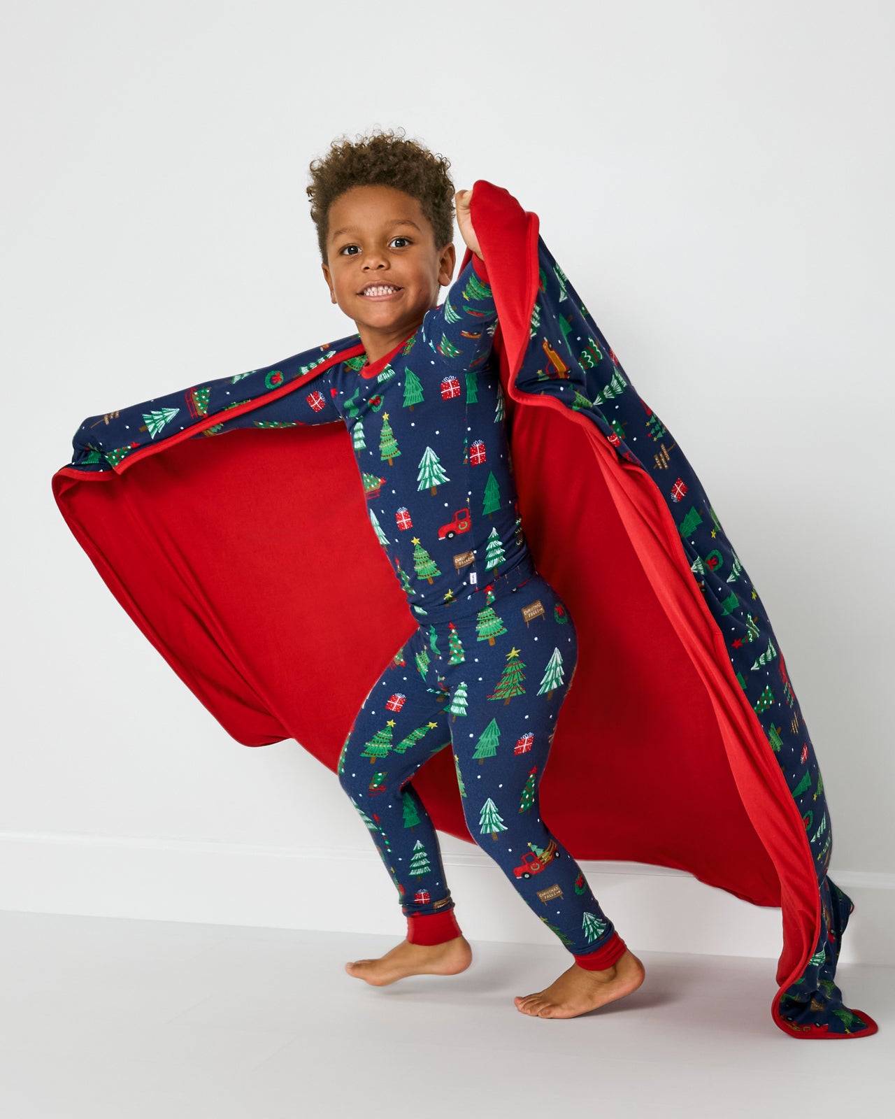 Child in motion holding the Navy Tree Traffic Large Cloud Blanket®