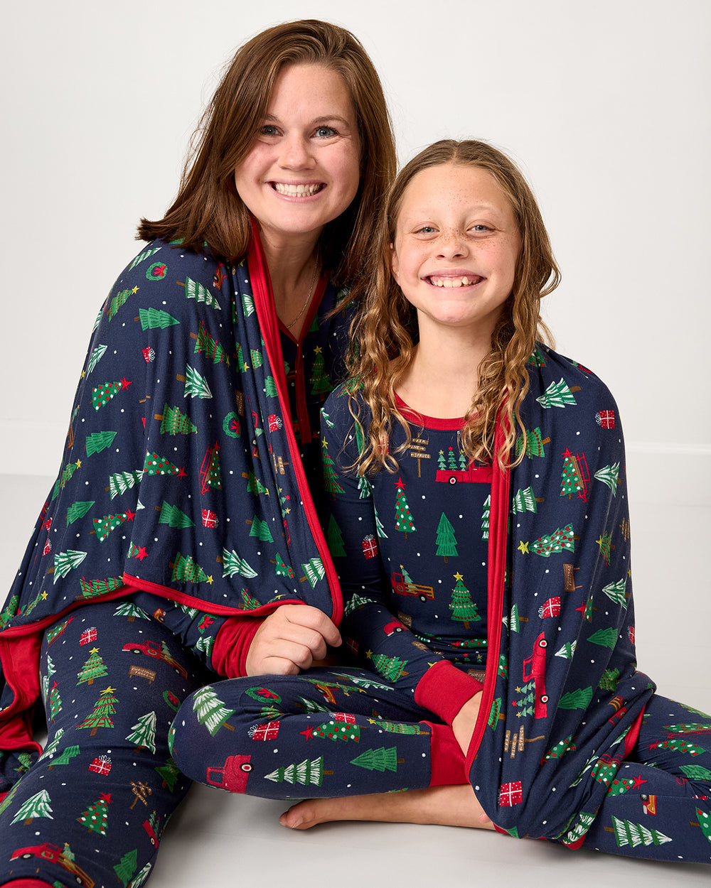 Mother and daughter wrapped in the Navy Tree Traffic Oversized Cloud Blanket®