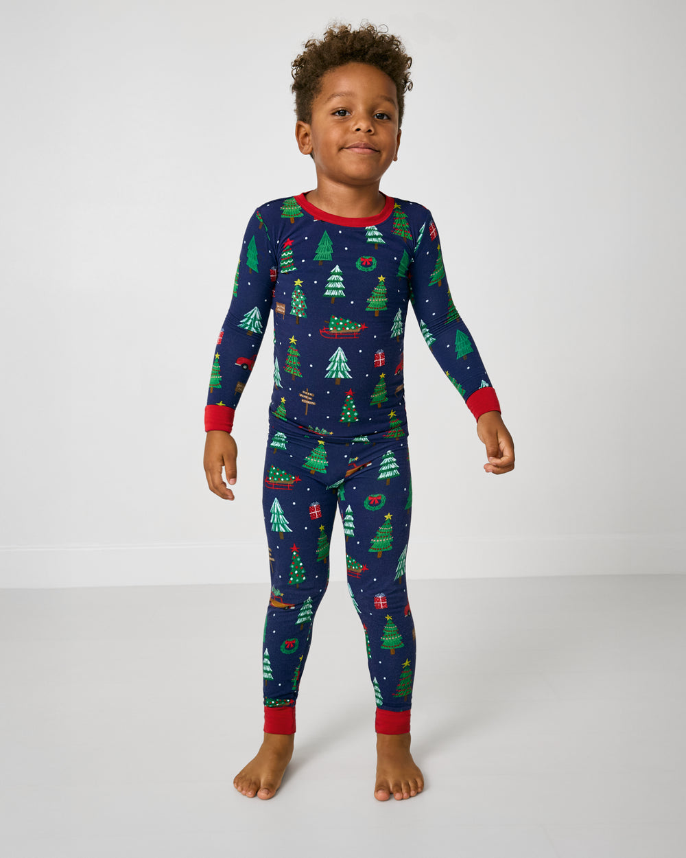 Standing boy wearing the Navy Tree Traffic Two-Piece Pajama Set