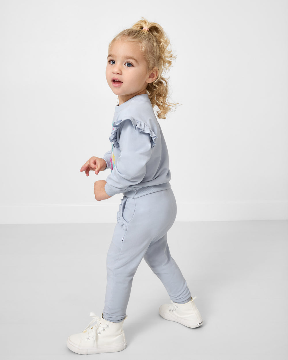 Girl wearing the Soft Blue Ruffle Jogger and Sweatshirt