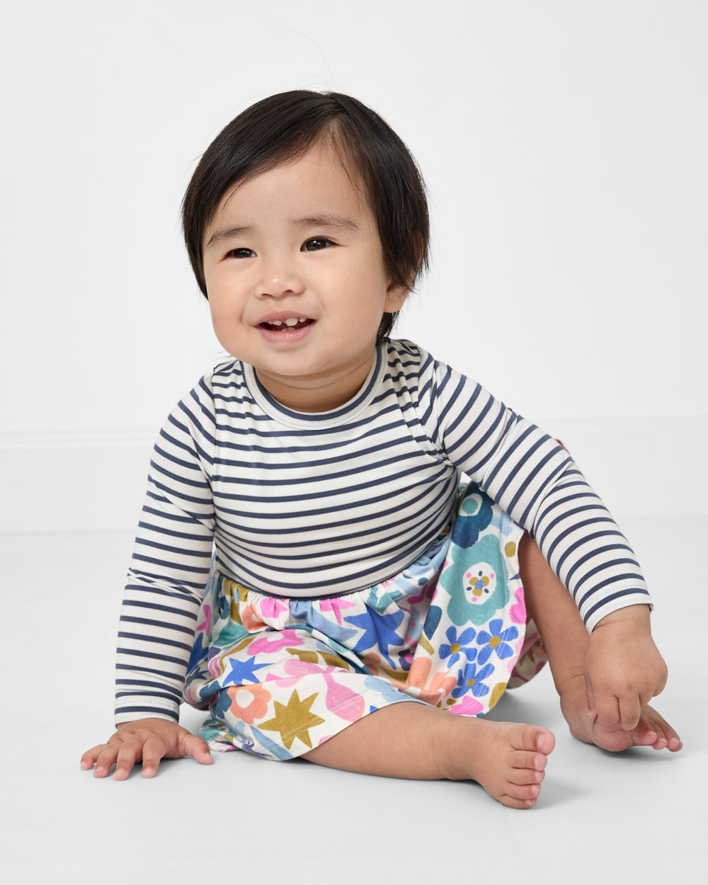 Sitting baby wearing the Unicorn Blossoms Twirl Dress with Bodysuit