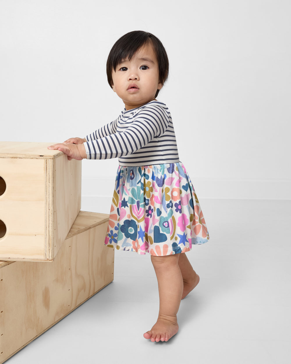 Standing child wearing the Unicorn Blossoms Twirl Dress with Bodysuit