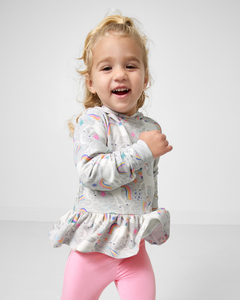 Running child wearing the Unicorn Dance Peplum Hooded Tee