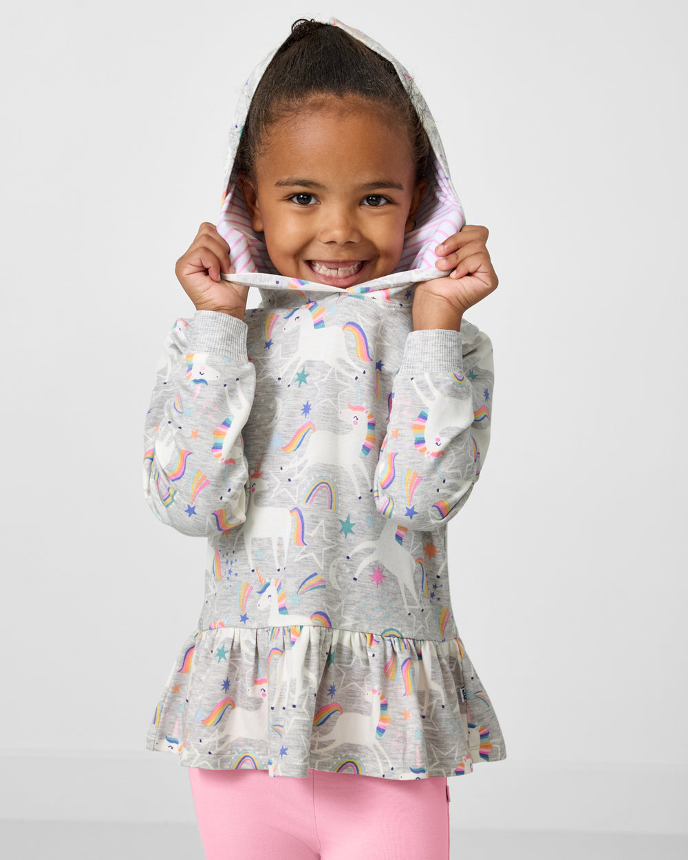 Girl wearing the Unicorn Dance Peplum Hooded Tee with the hood on