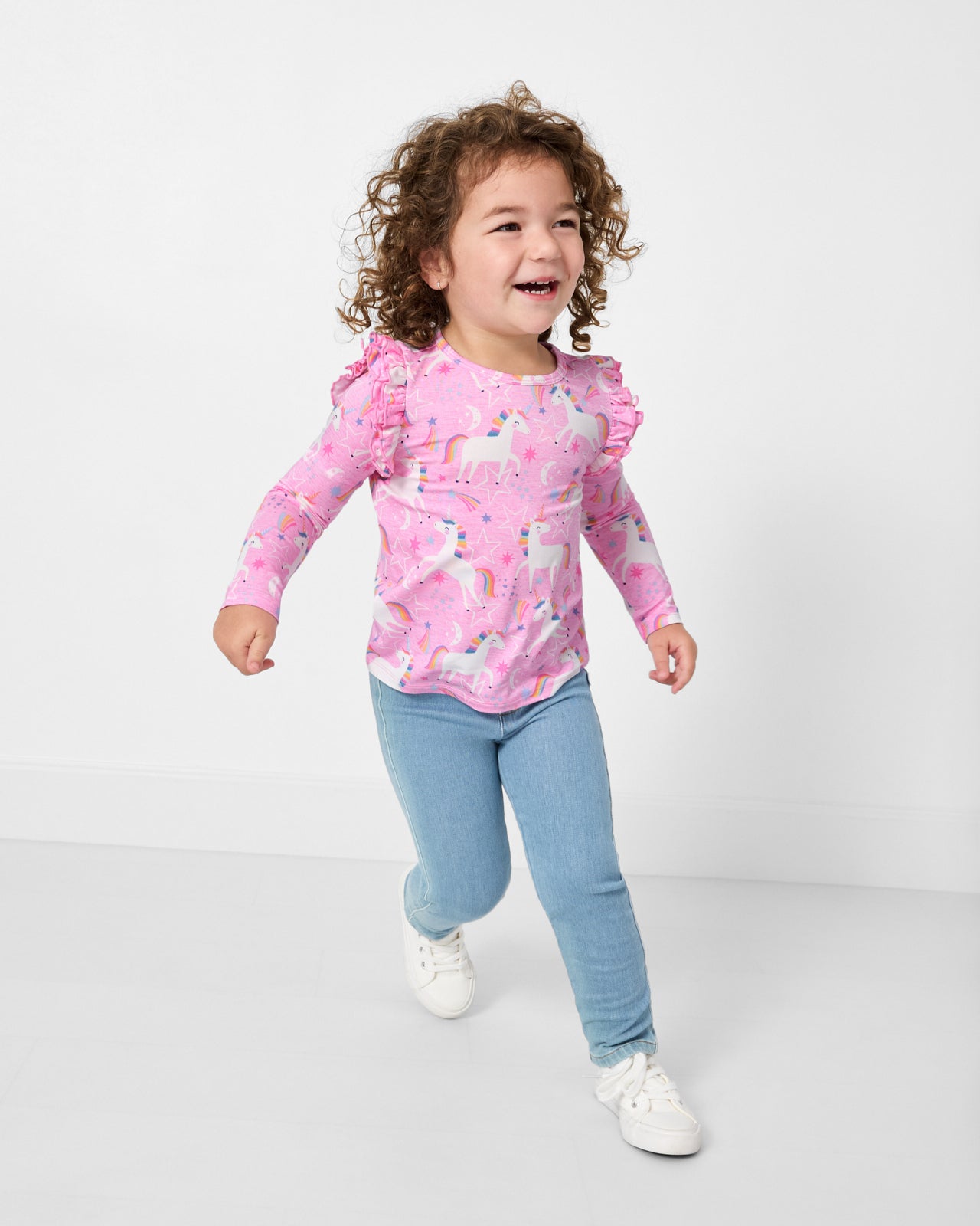 Running child wearing the Unicorn Dance Flutter Tee with jeans