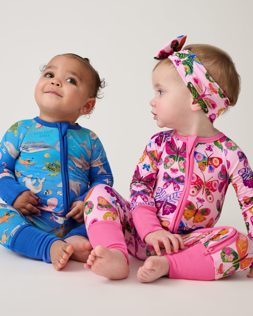 Two babies wearing nature themed footie pajamas