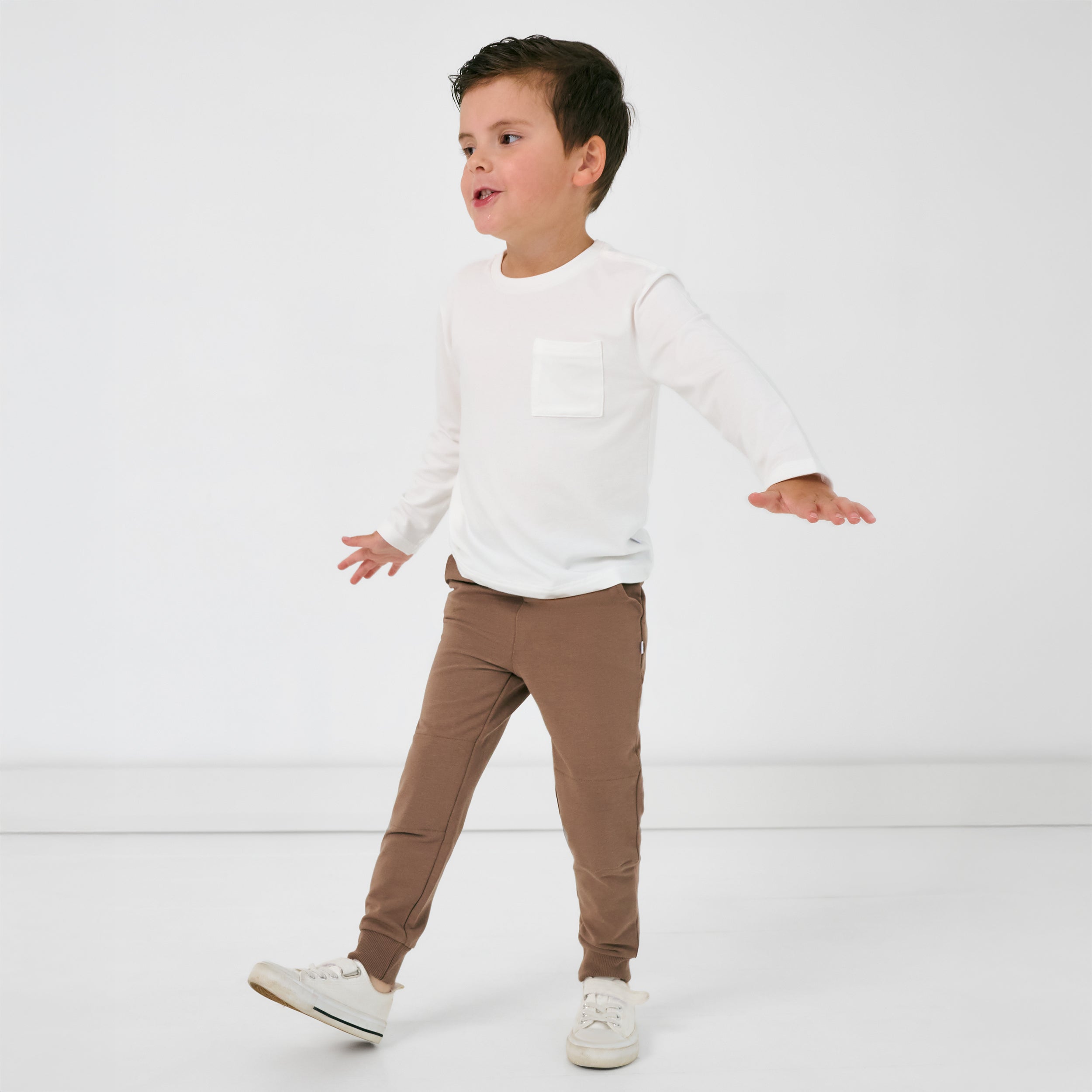 Walking child wearing the Vintage Brown Jogger and white long sleeve pocket tee