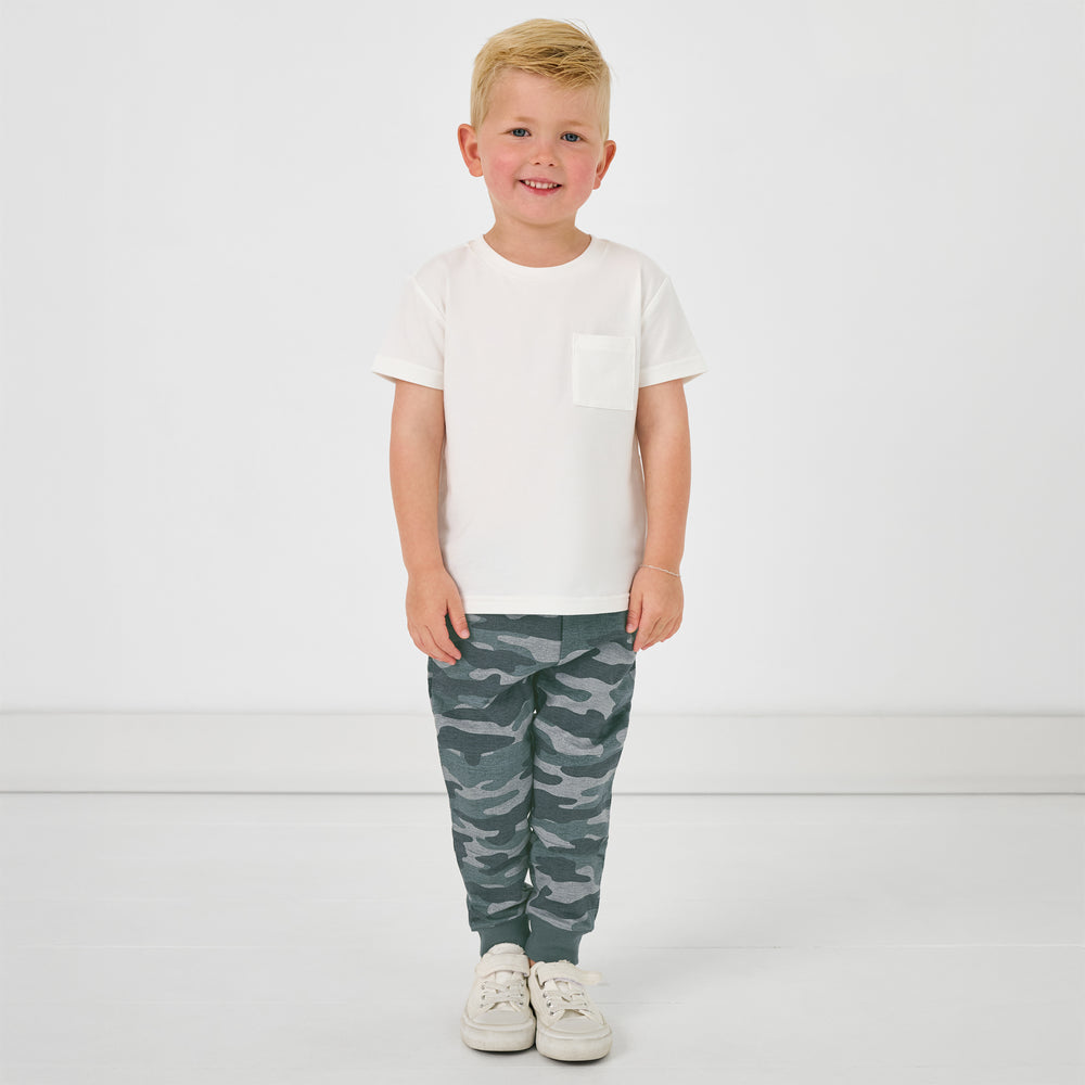 Standing child wearing the Vintage Camo Jogger with a white pocket tee