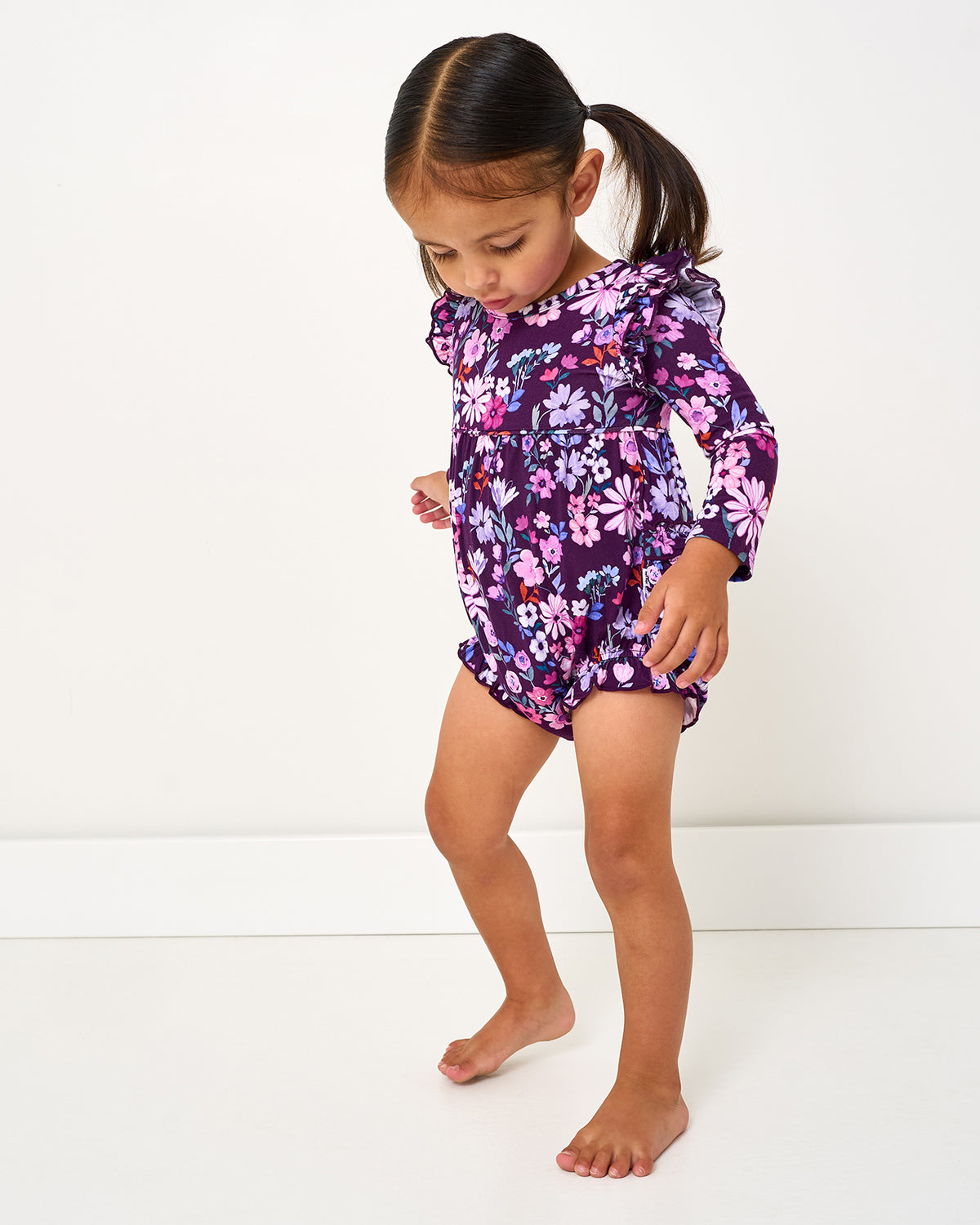 Walking toddler wearing the Violet Meadow Bubble Romper