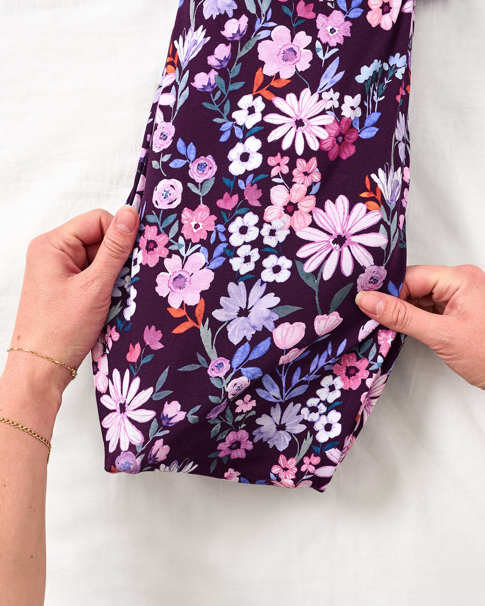 Adult adjusting the envelope sweep on the Violet Meadow Infant Gown